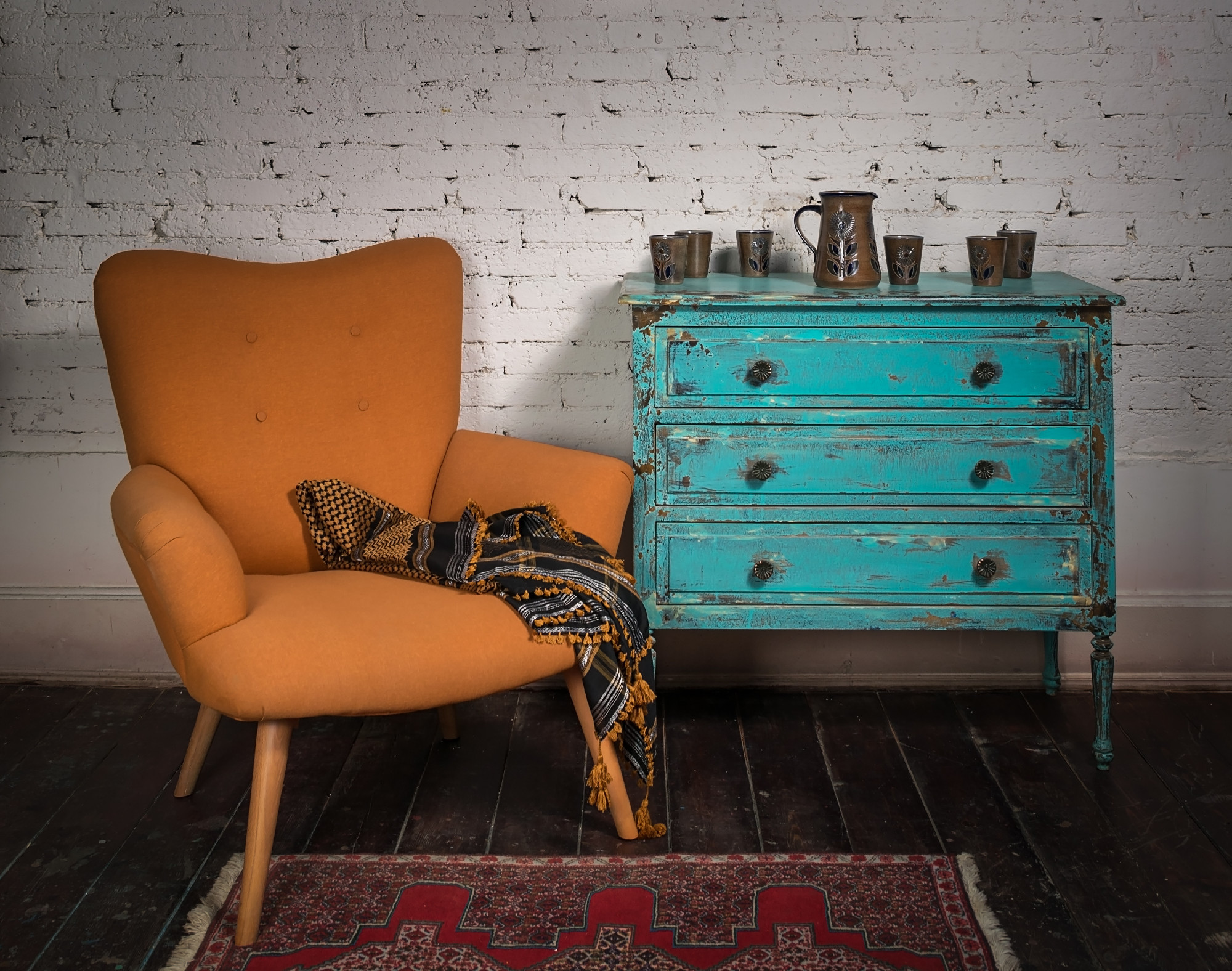 Vintage orange armchair, blue cabinet and ornate scarf