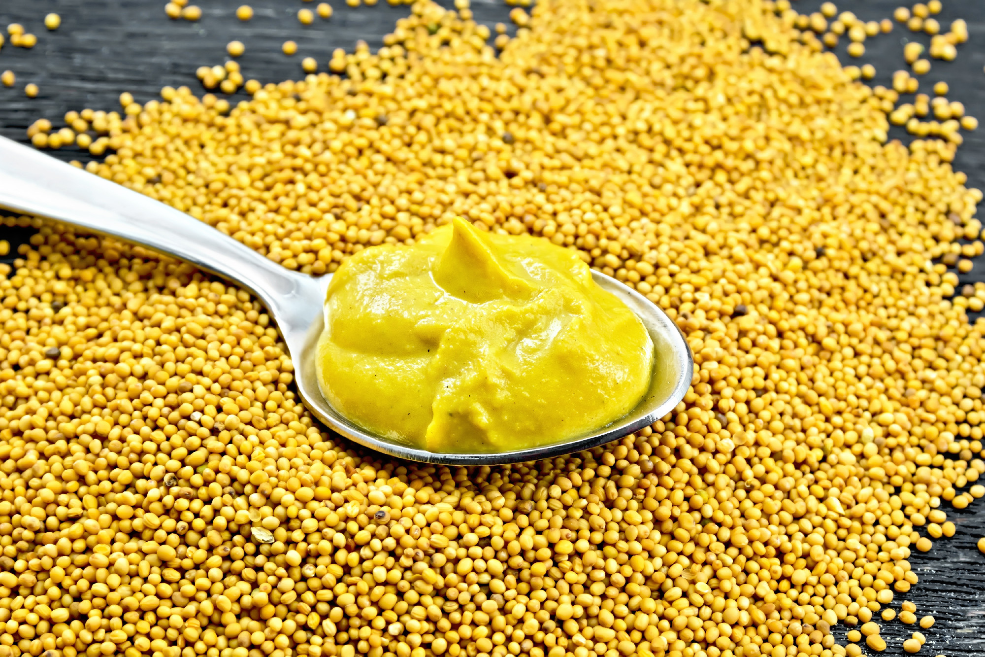 Sauce mustard in spoon on seeds