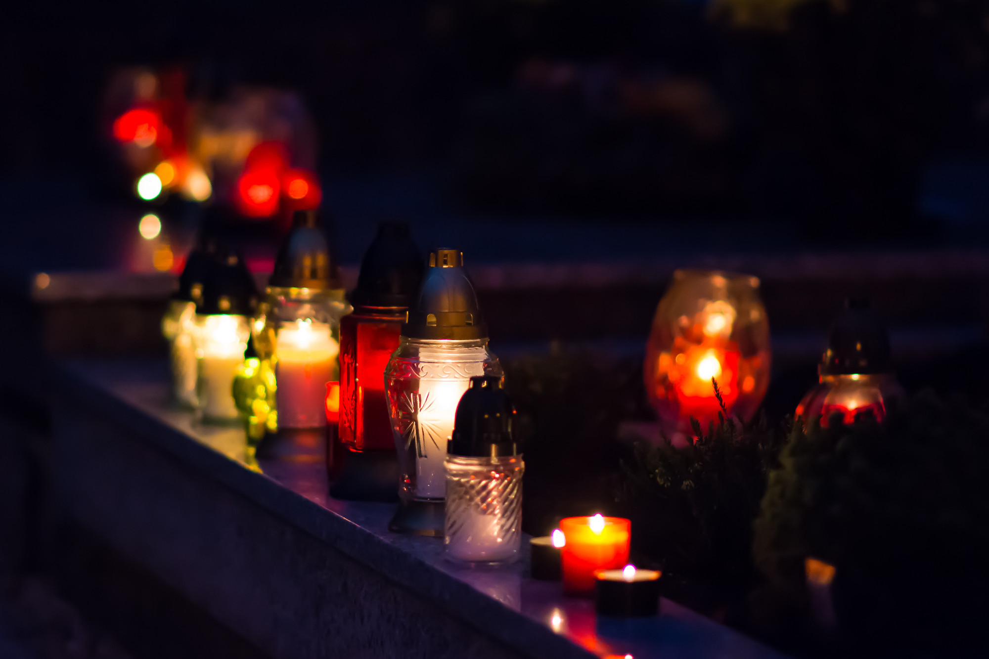 Flaming colored candle on the grave