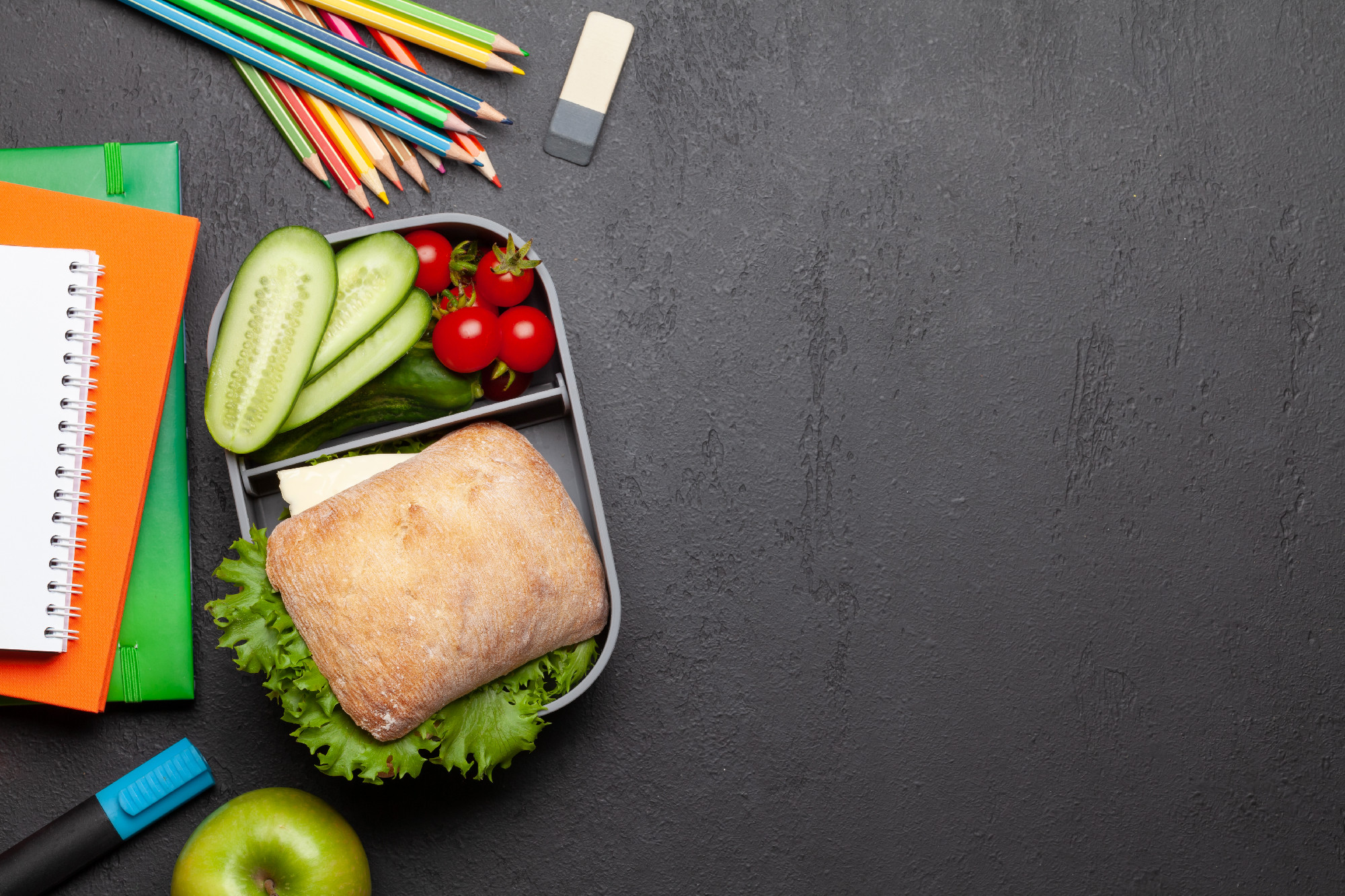 Lunch box with sandwich, vegetables and juice