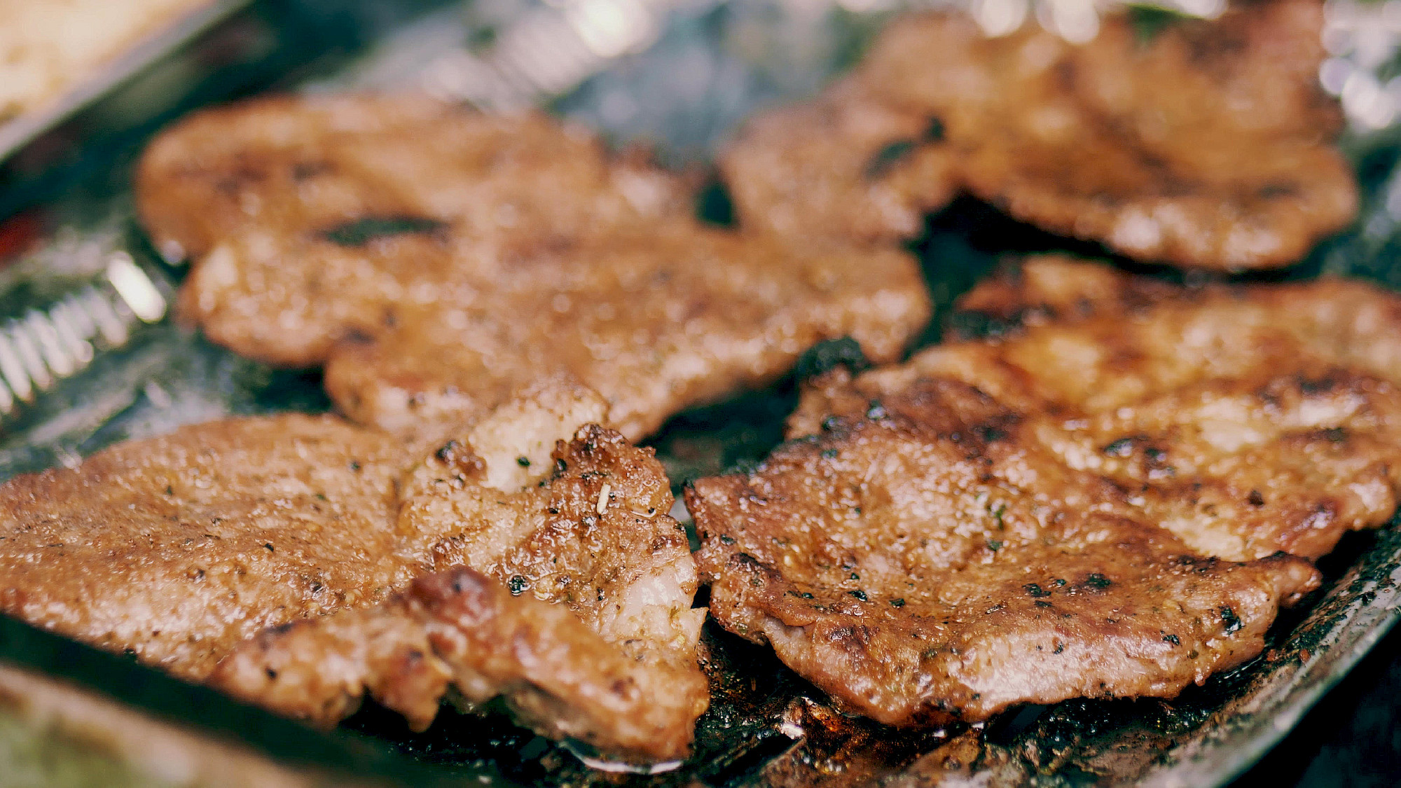 Roasting sizzling meat on the barbecue, close-up shot