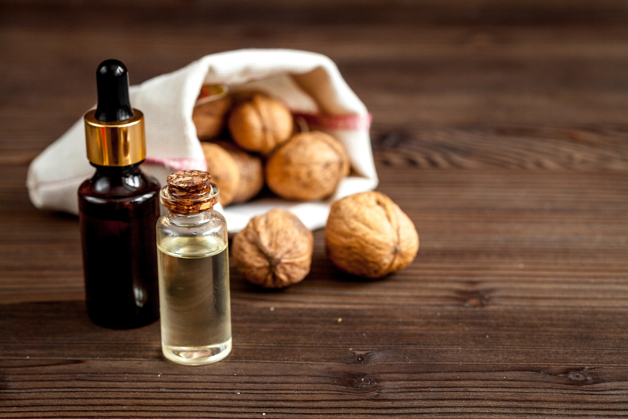 cosmetic and therapeutic walnut oil on dark wooden background
