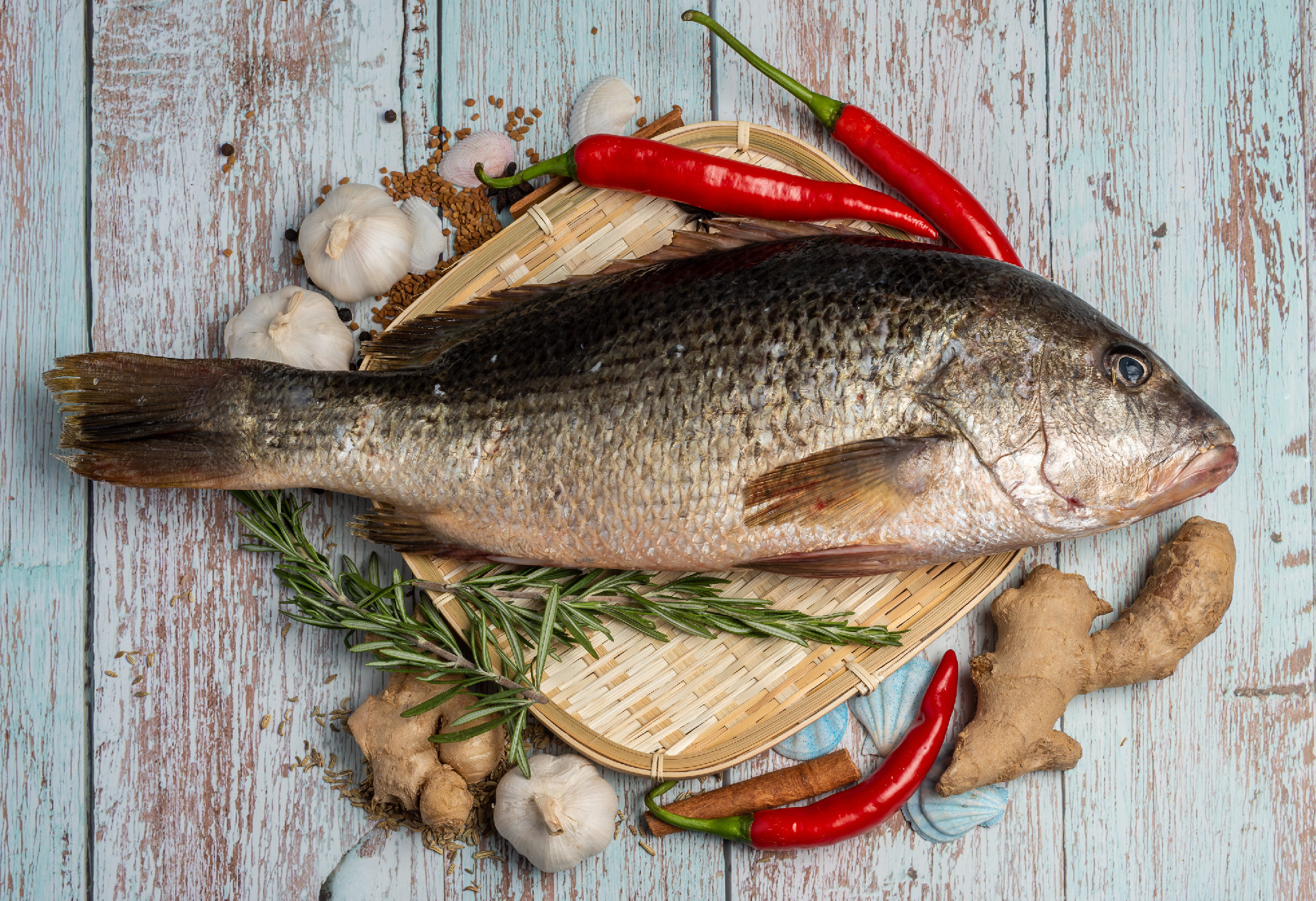 Fresh Fatty Fish on wooden table on wooden table Bass on rattan