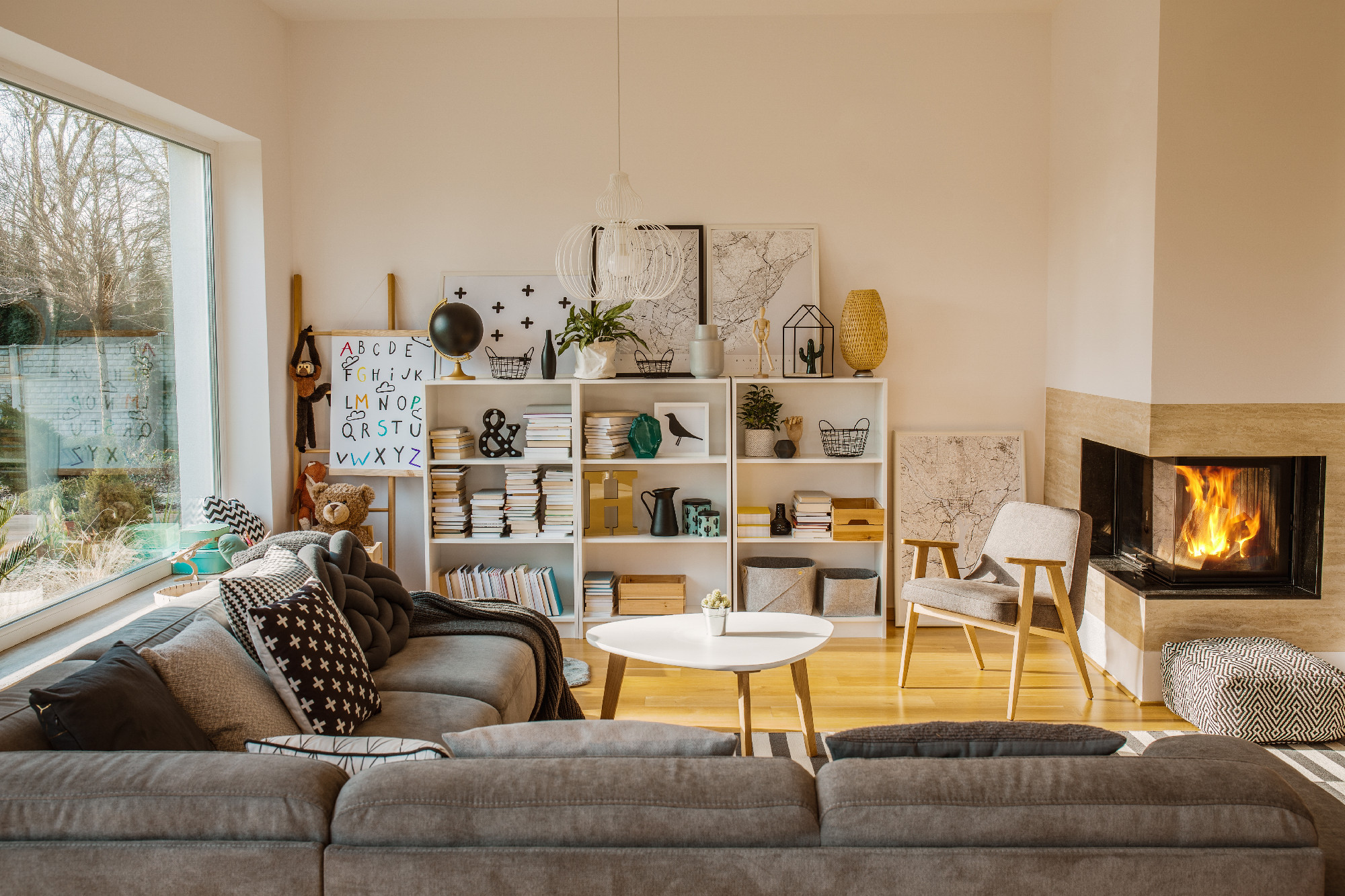 White Scandinavian living room interior with fireplace, posters,