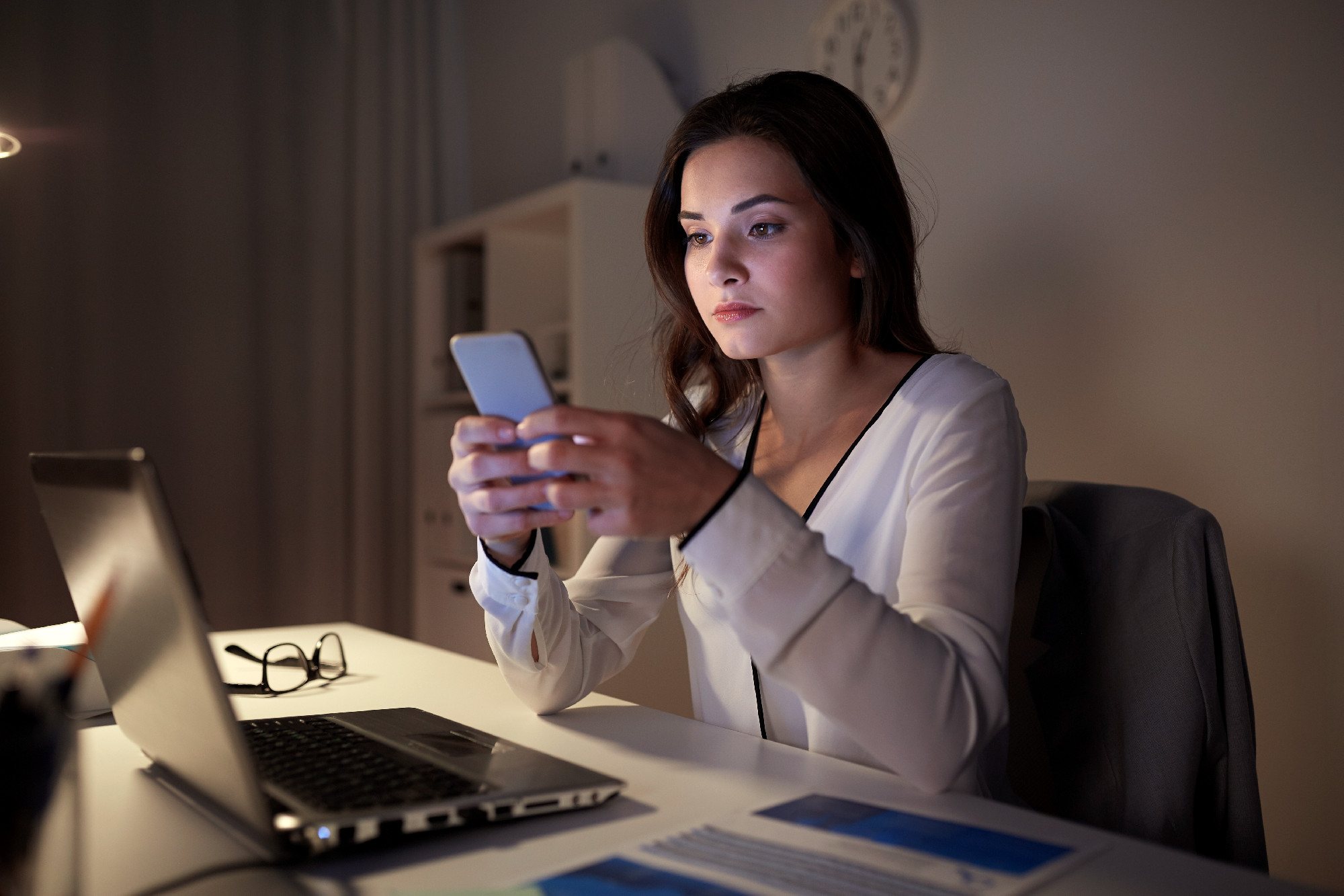 businesswoman with smartphone and laptop at office