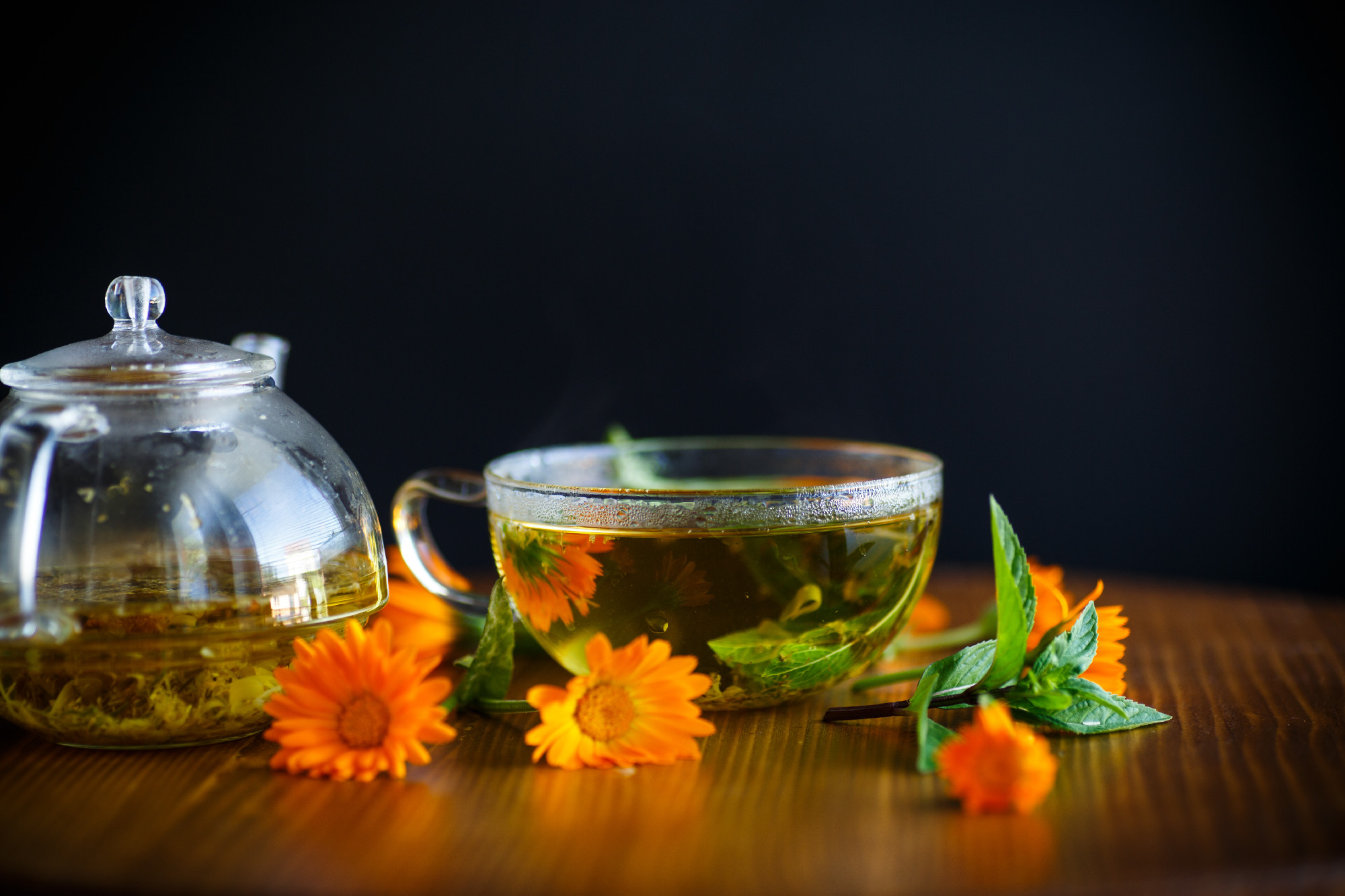 fresh hot tea with calendula on a wooden table