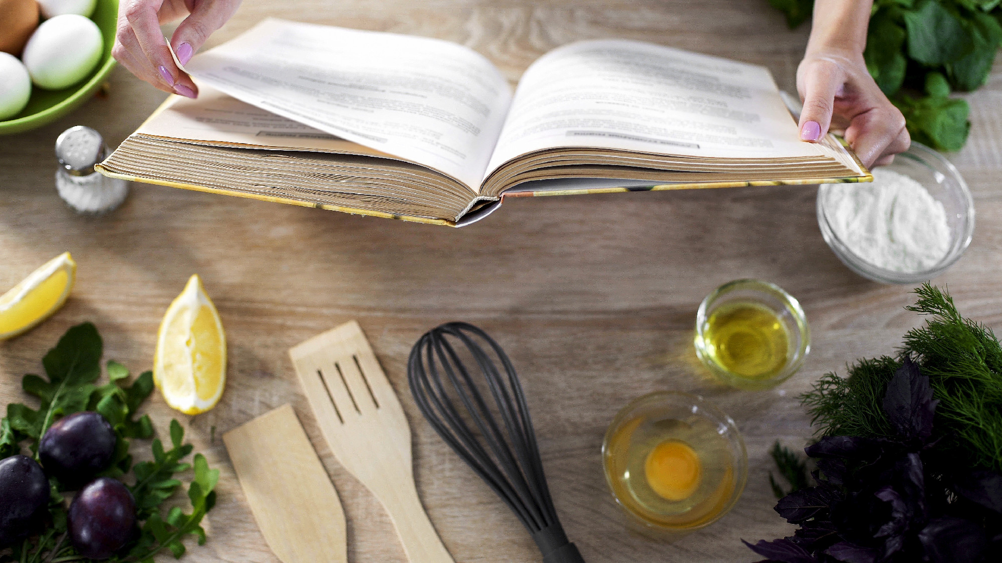 Woman hands holding cooking book table, girl choosing recipe for