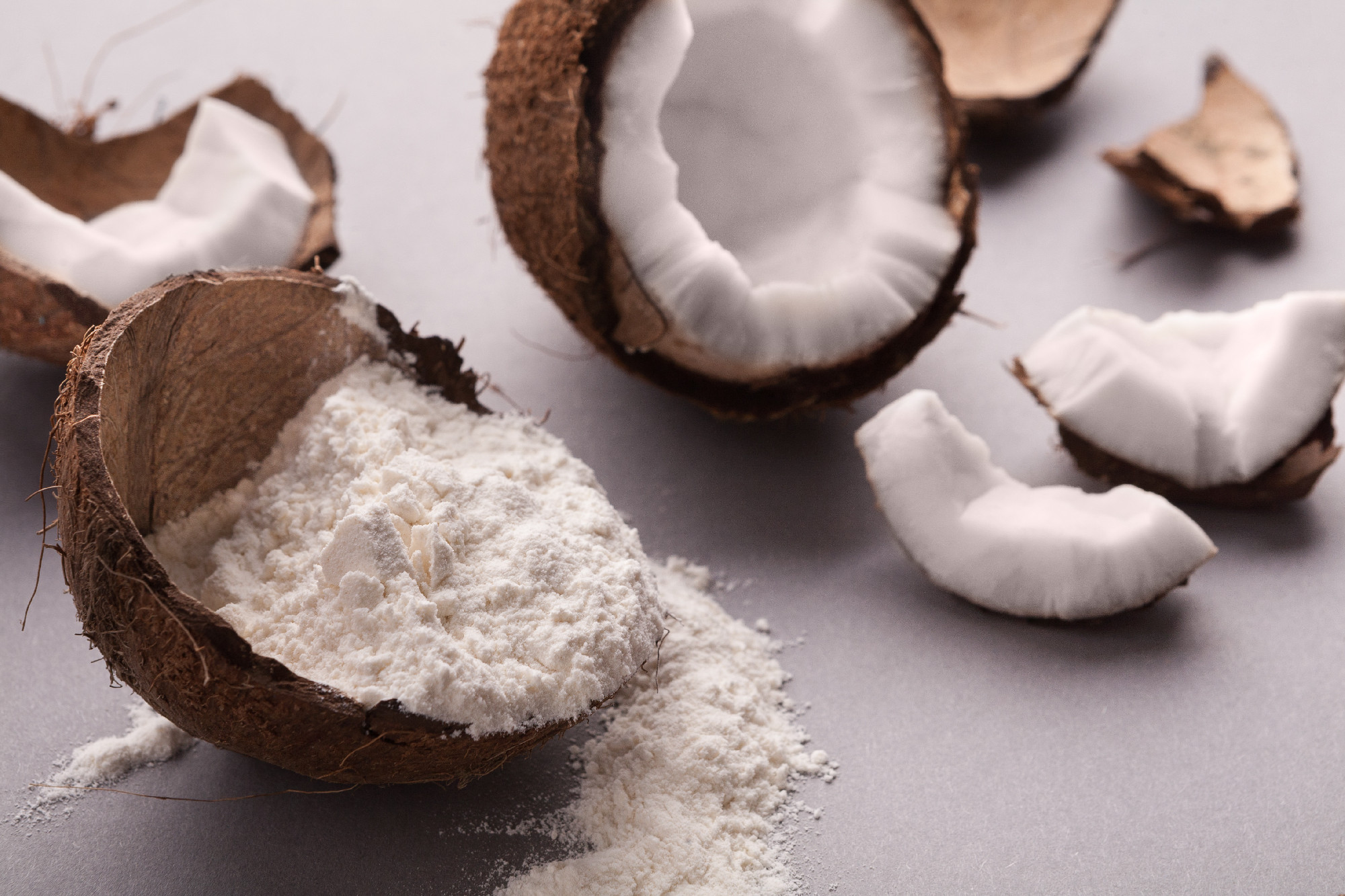 Coconut flour and nuts on grey background