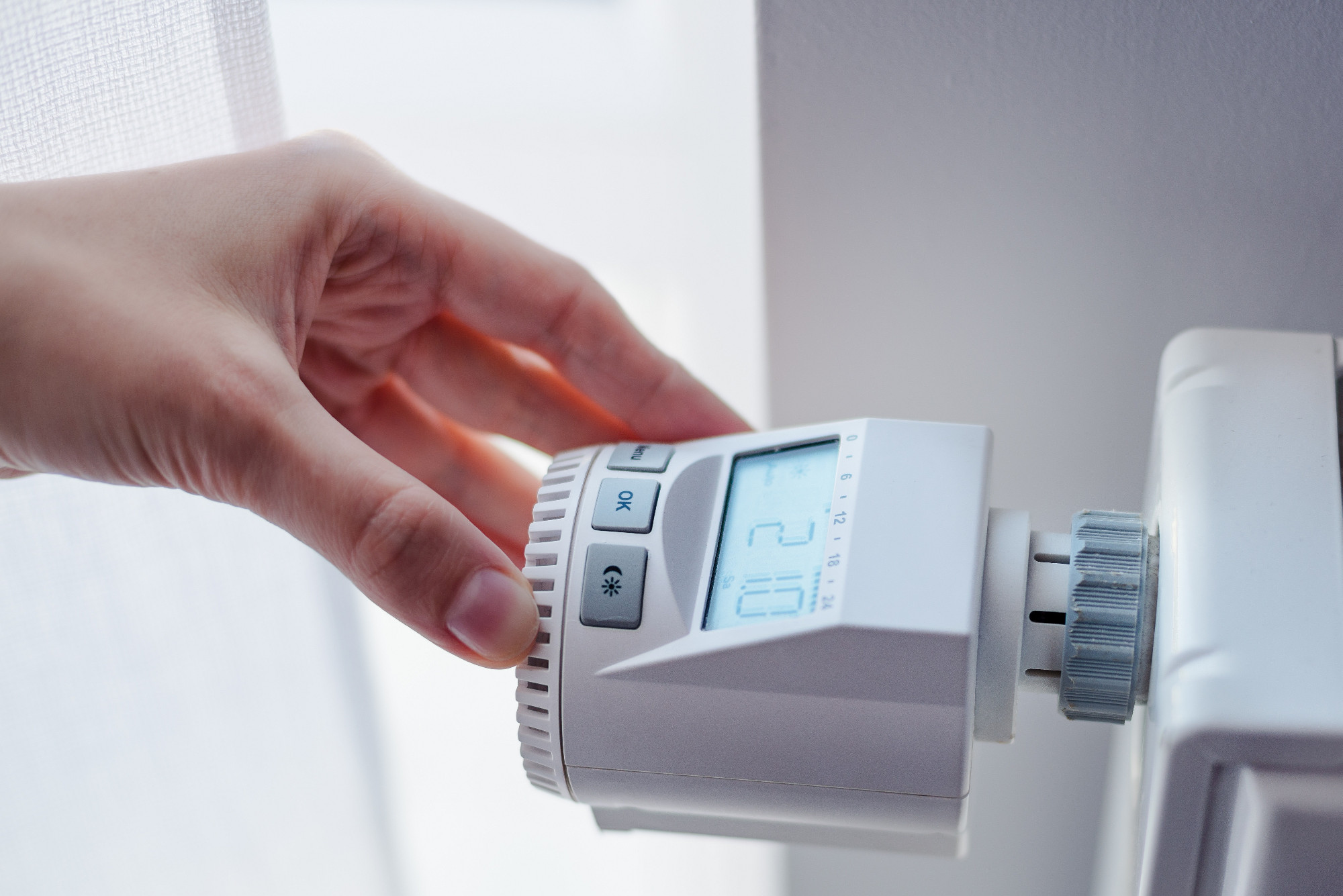 Woman adjusting temperature of home heater