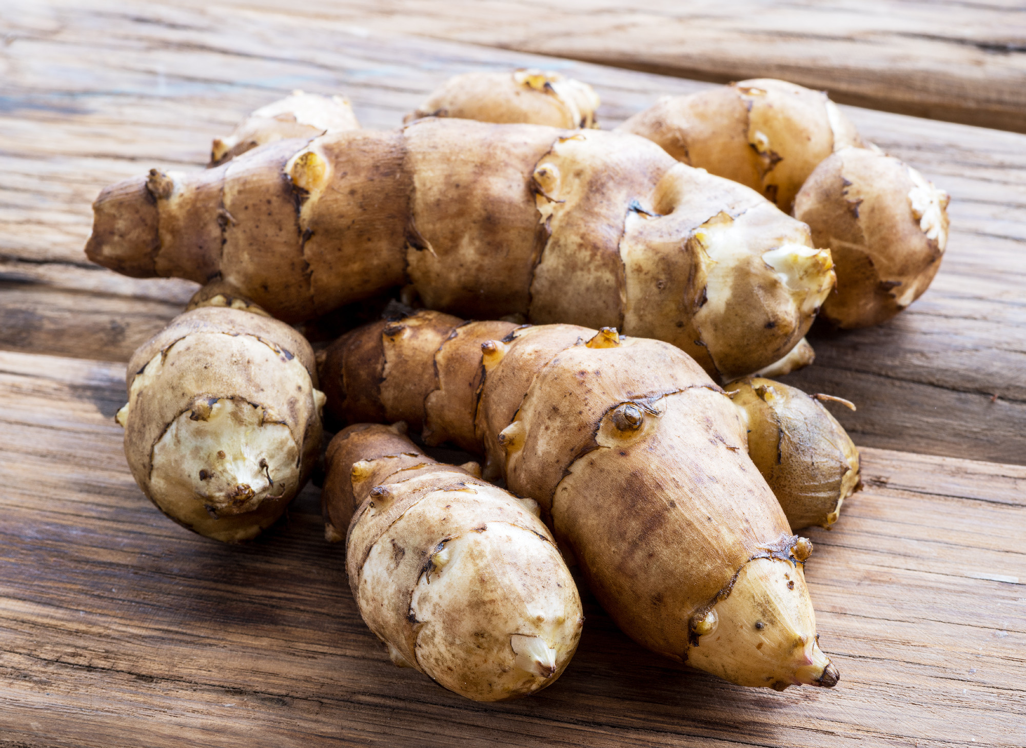 Jerusalem artichoke on wooden background.