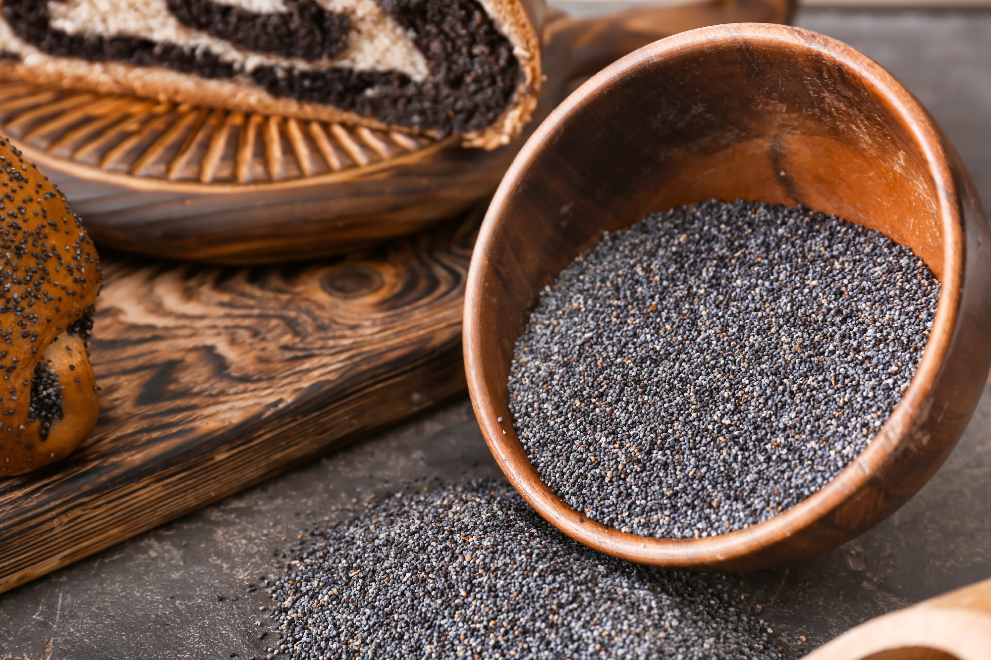 Bowl with poppy seeds on table�