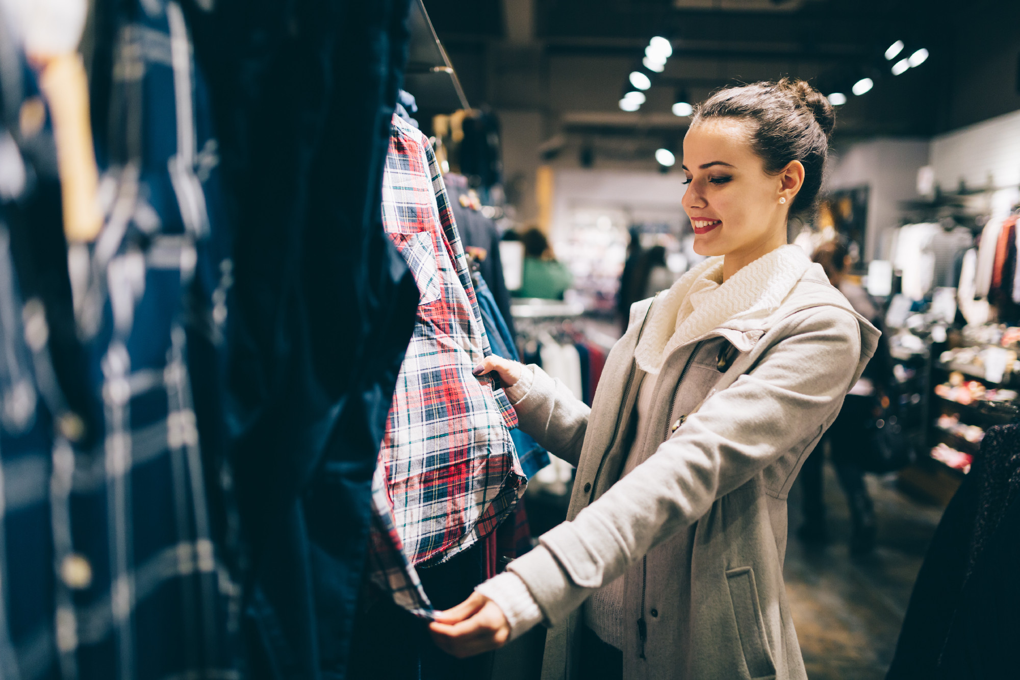 Young attractive woman buying clothes in mall