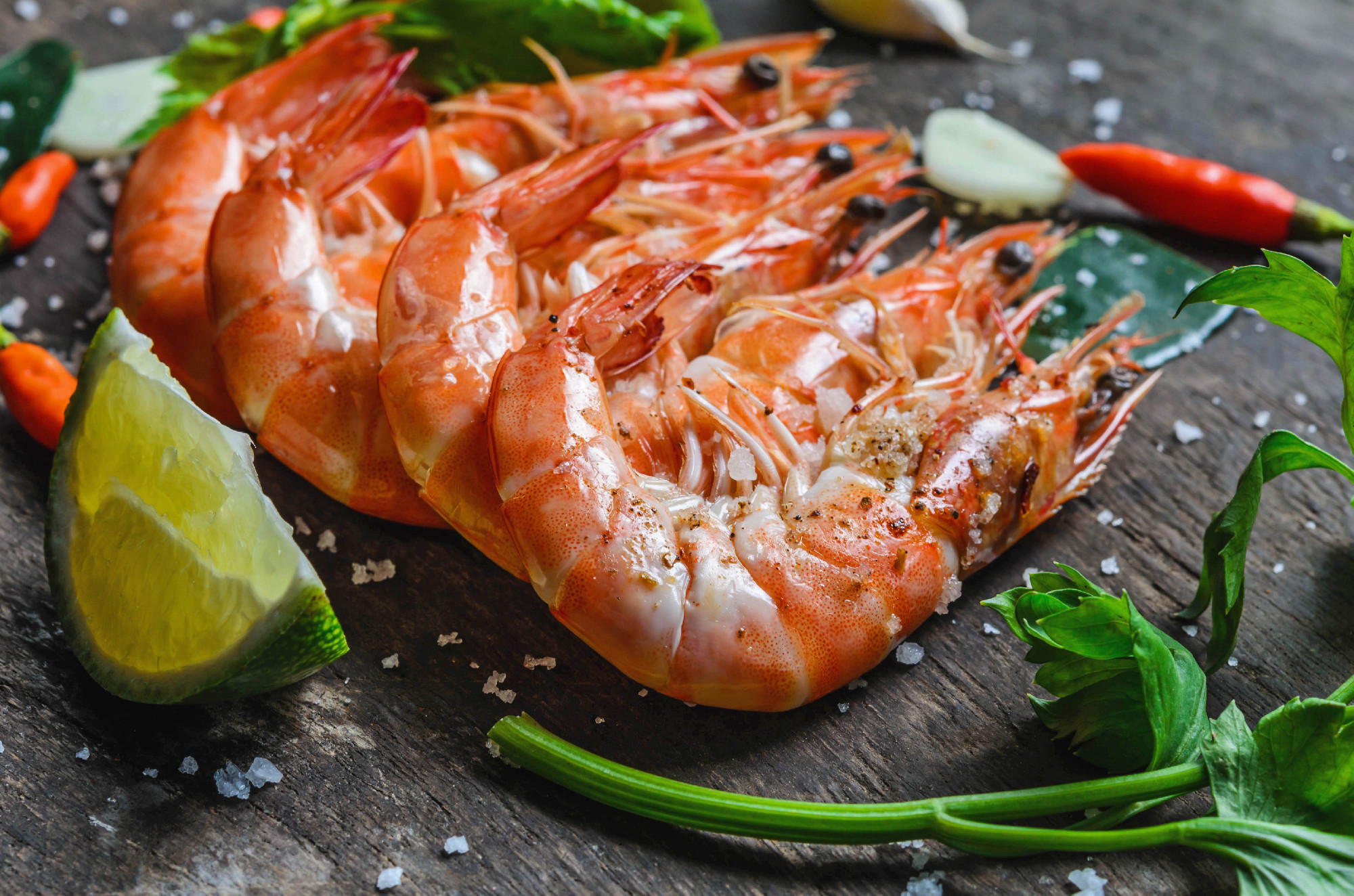 close up shrimps and lemon with chilli on wood background