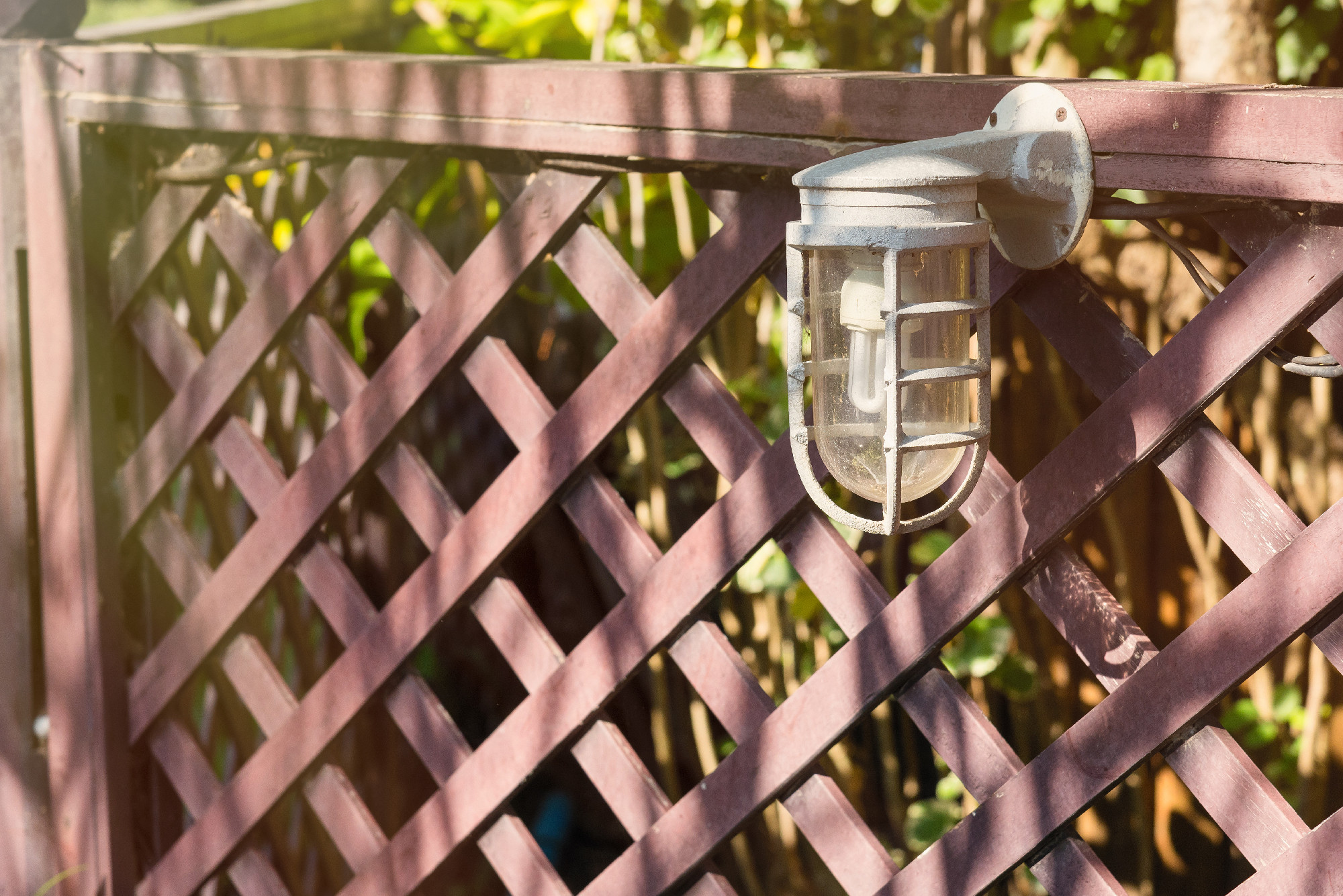 Lamps for illumination on a wooden fence in the garden.