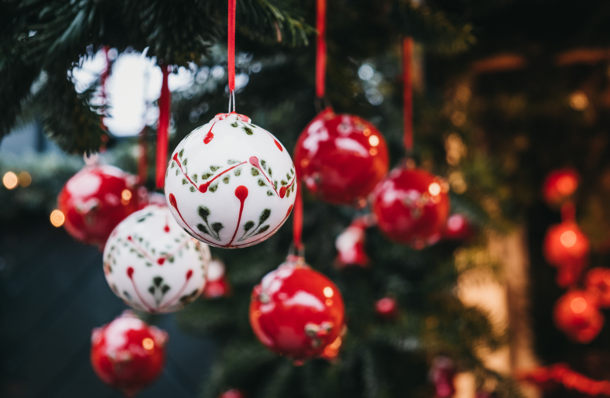 Red and white Christmas tree decorations on sale at a Christmas