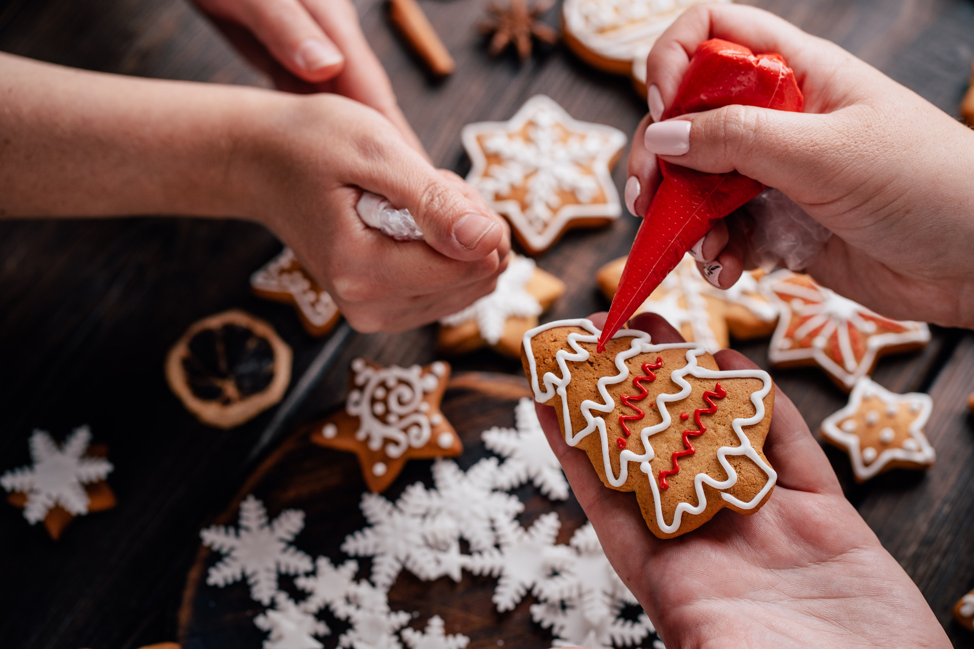 Friends decorating christmas gingerbread cookies