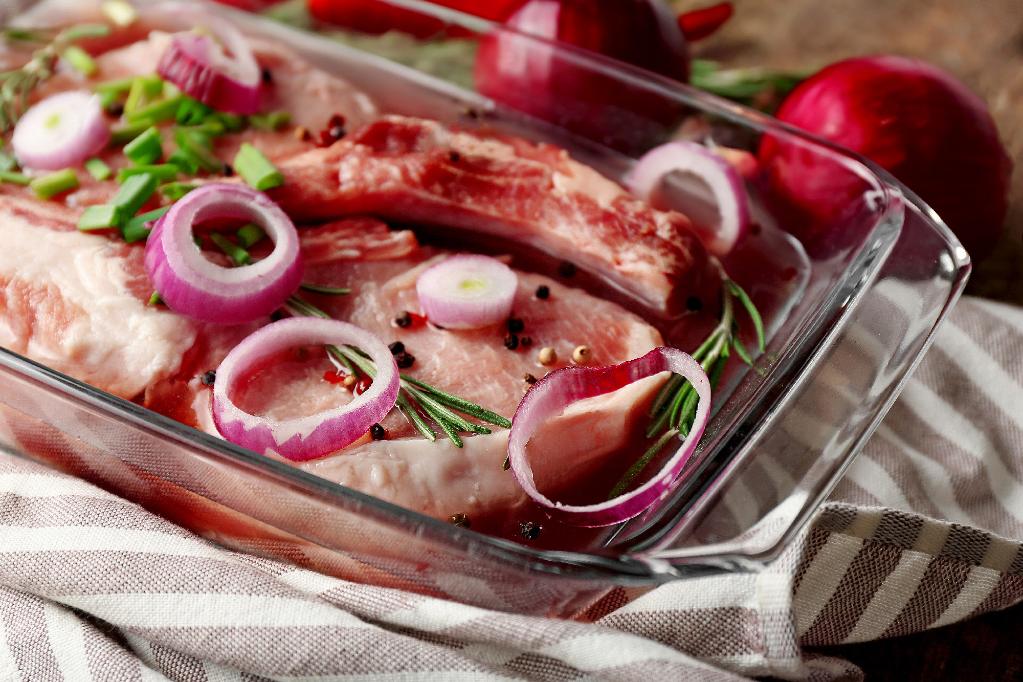 Marinating meat with spices on wooden table