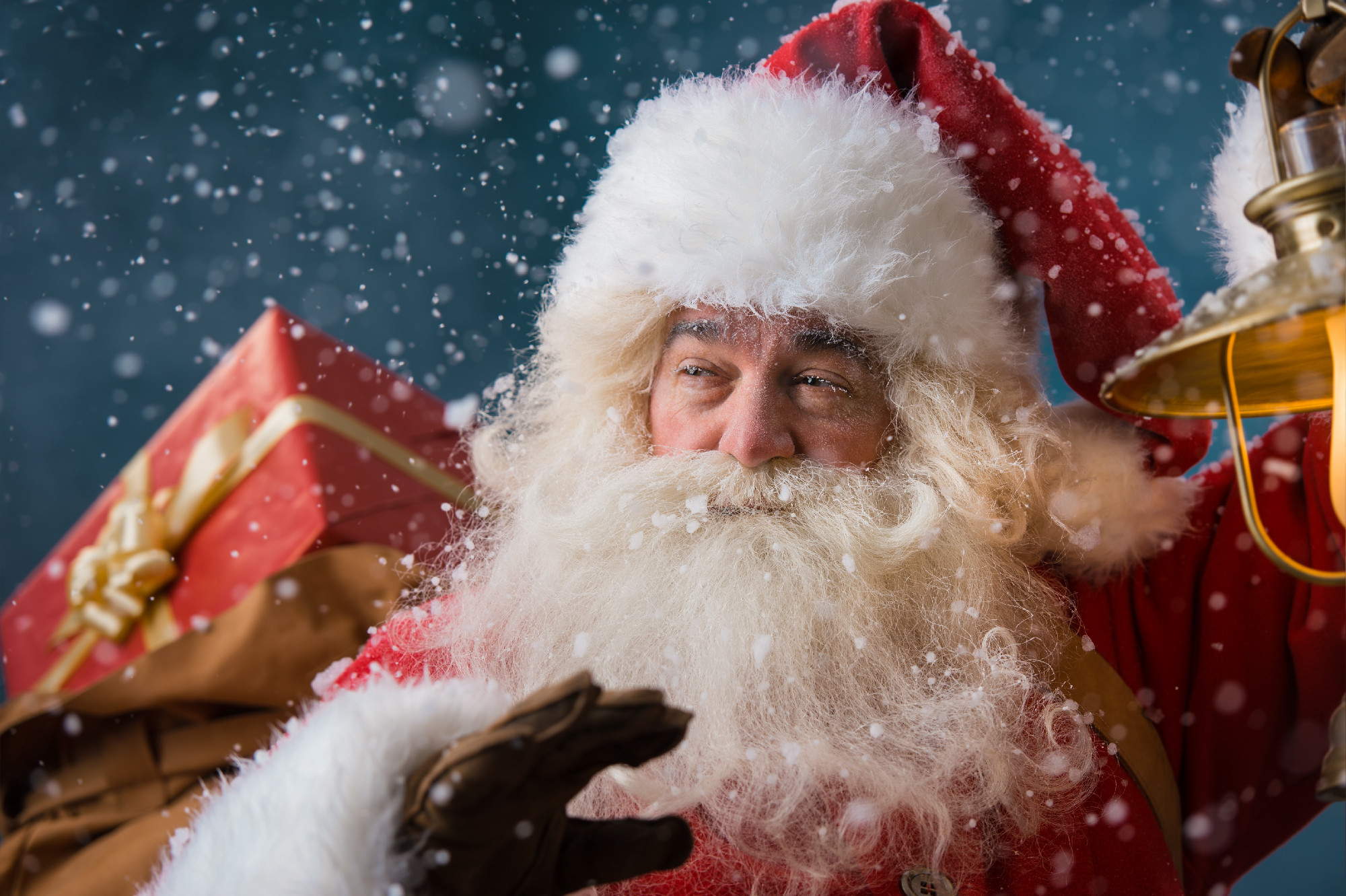 Santa Claus walking on the snow with his sack of gifts