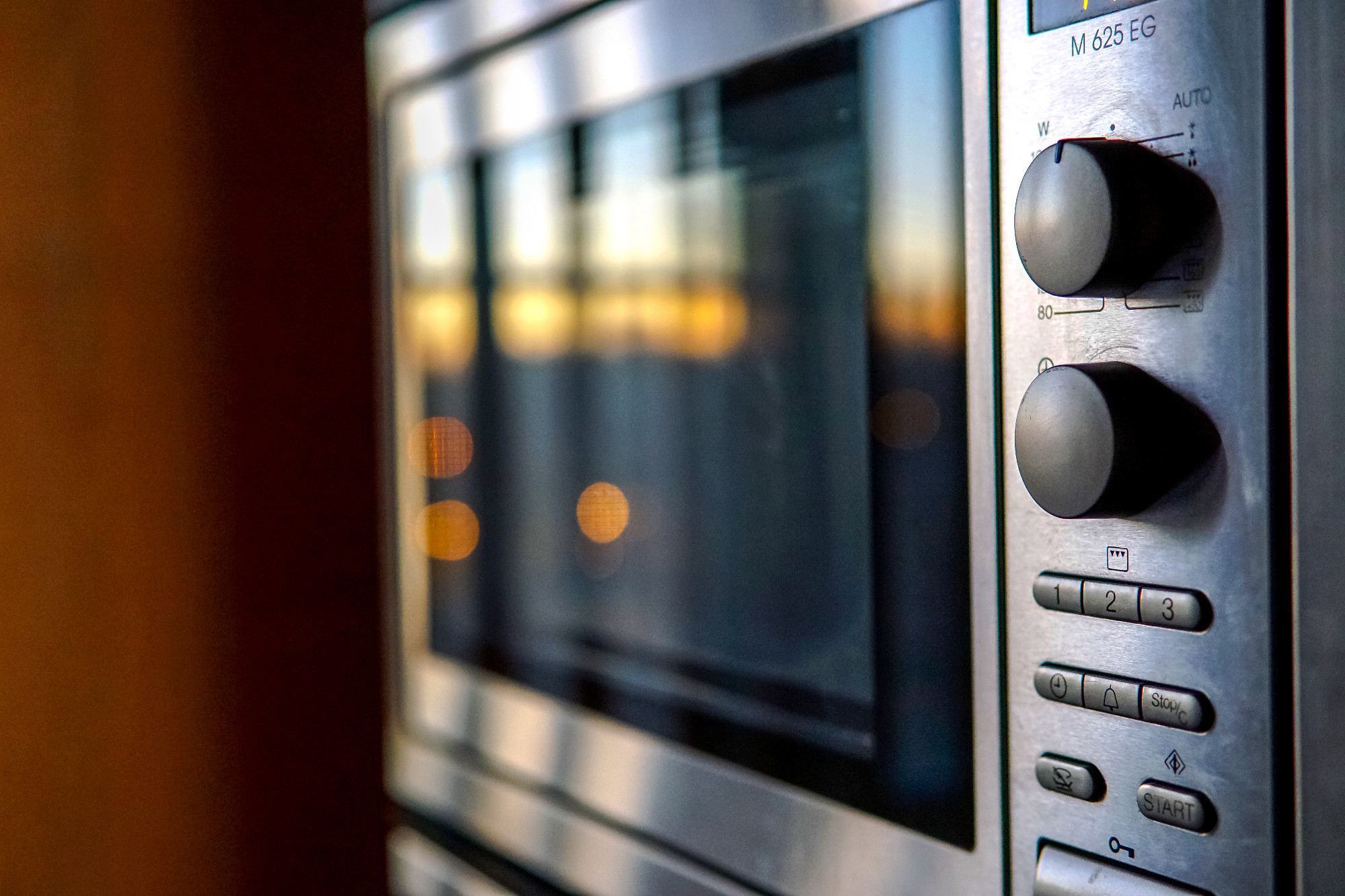 modern built in kitchen appliances in stainless steel. sunset reflections