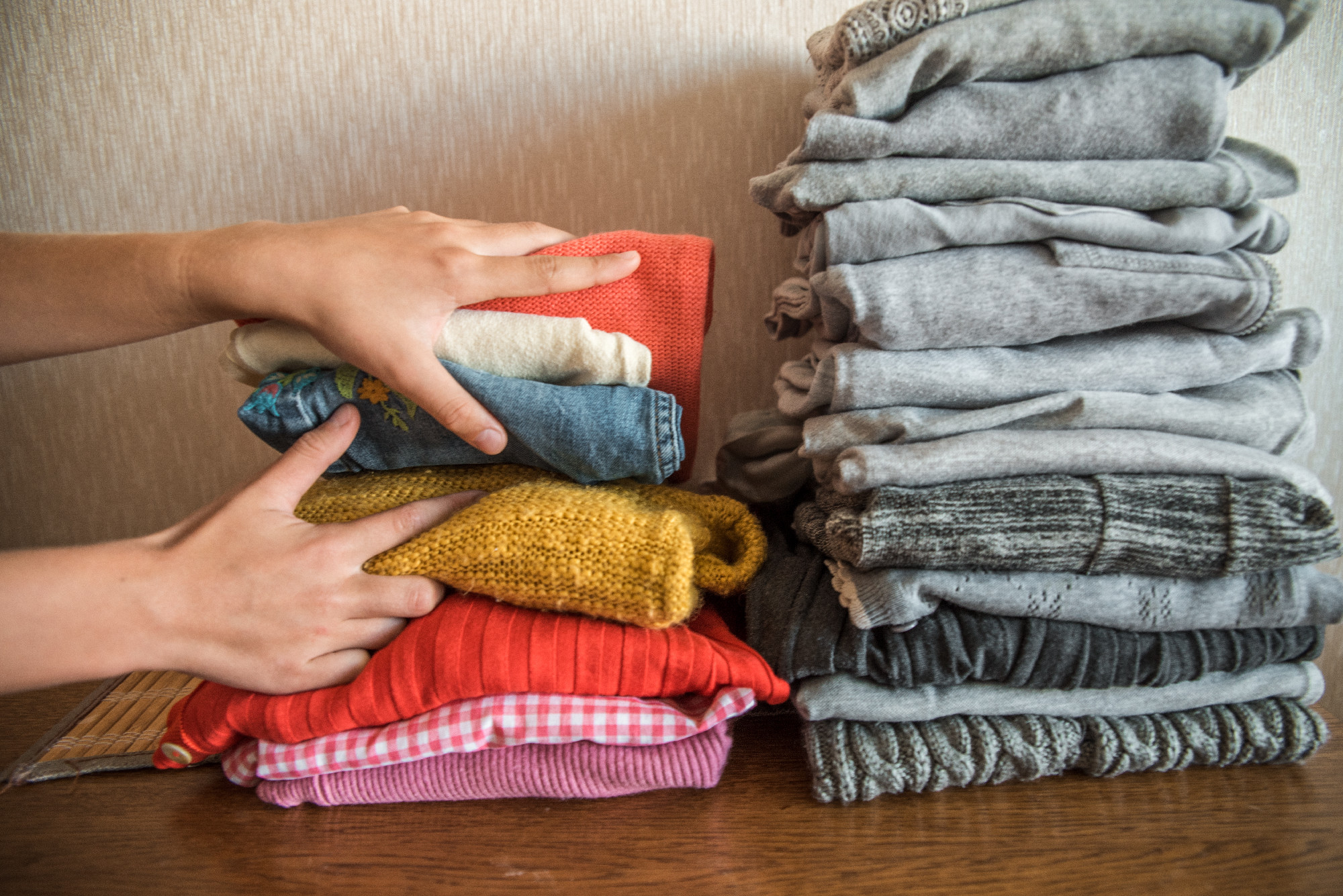 Red orange and yellow bright stack of clothes against the gray. The concept of choice and individuality