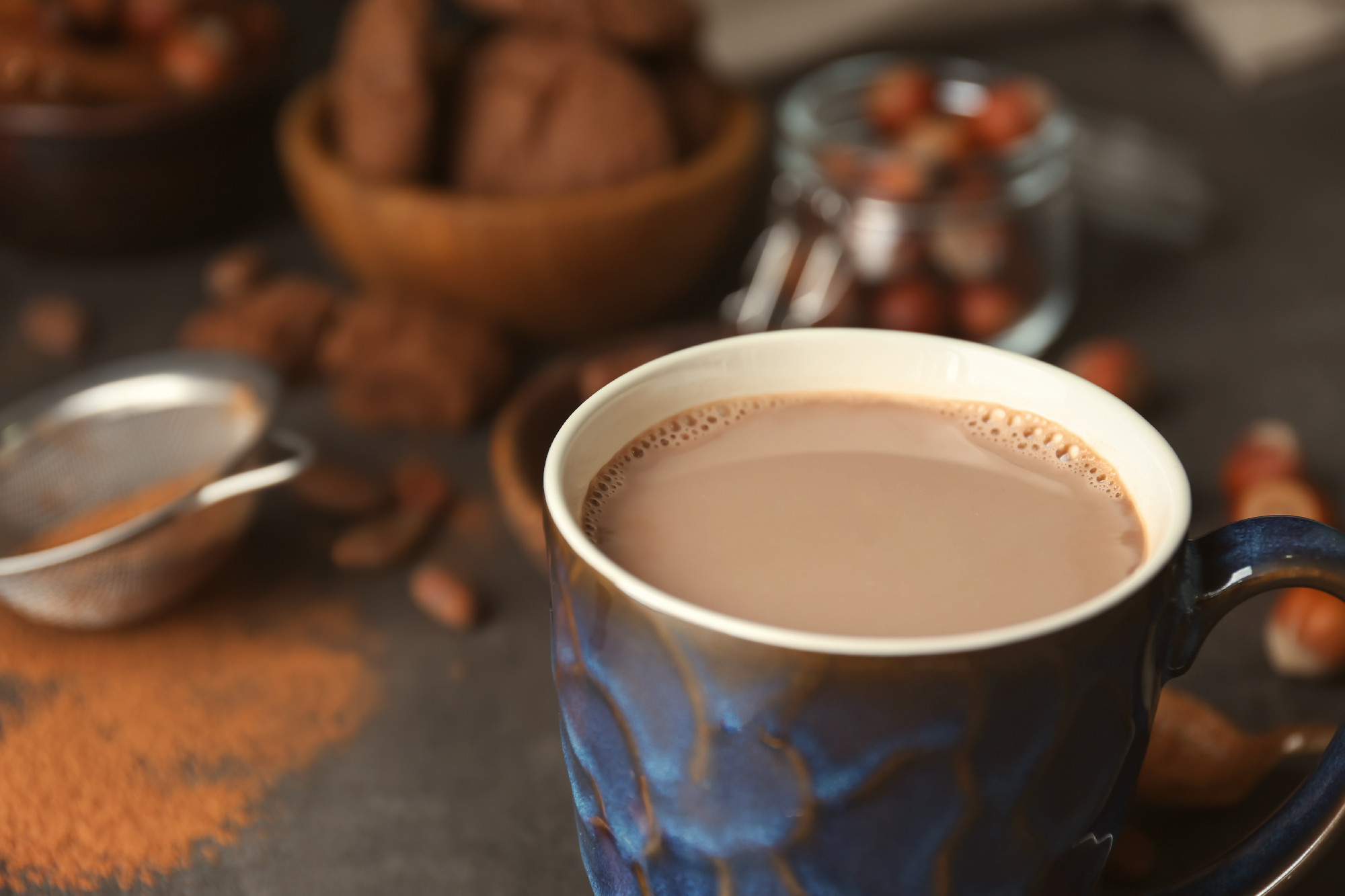 Cup with hot cocoa drink on table�