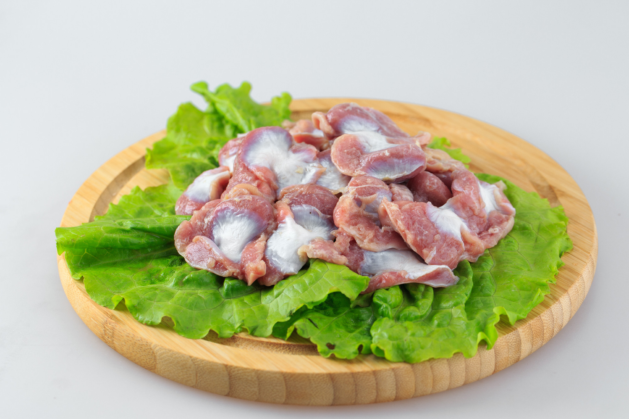 raw chicken gizzards on a white background.