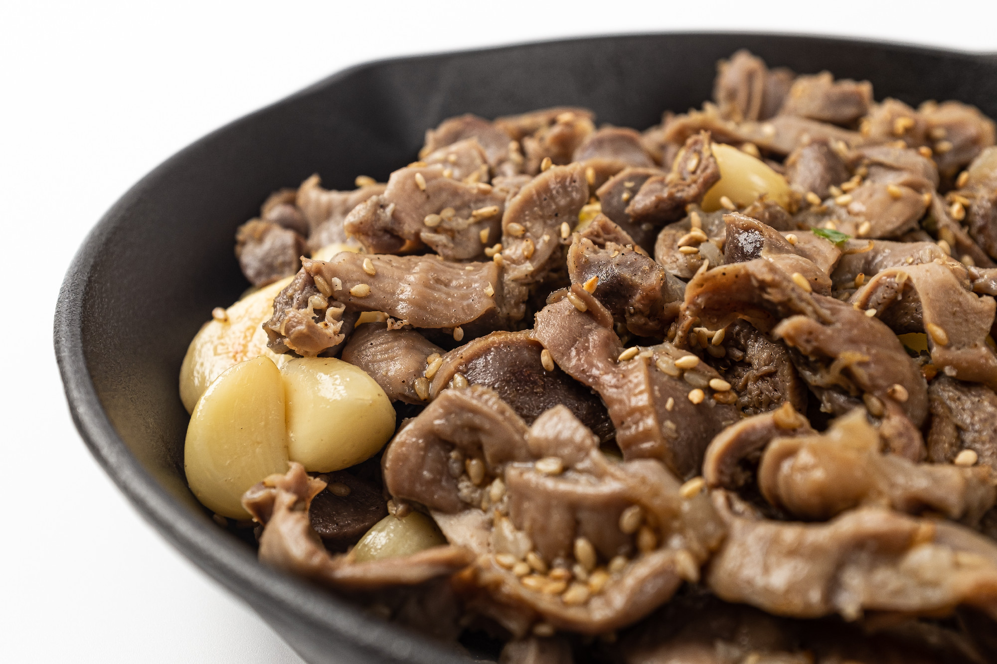 Stir-fried chicken gizzards and garlic on a white background