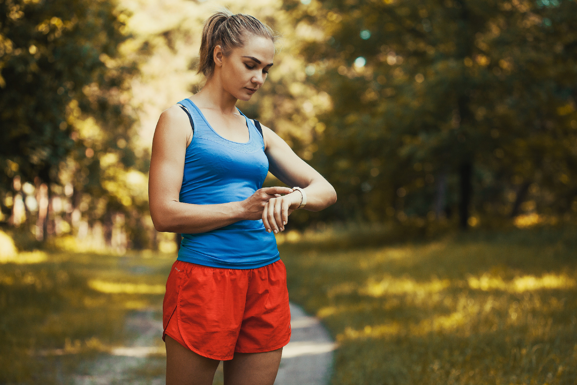 Pretty woman athlete doing exercises before jogging through the woods