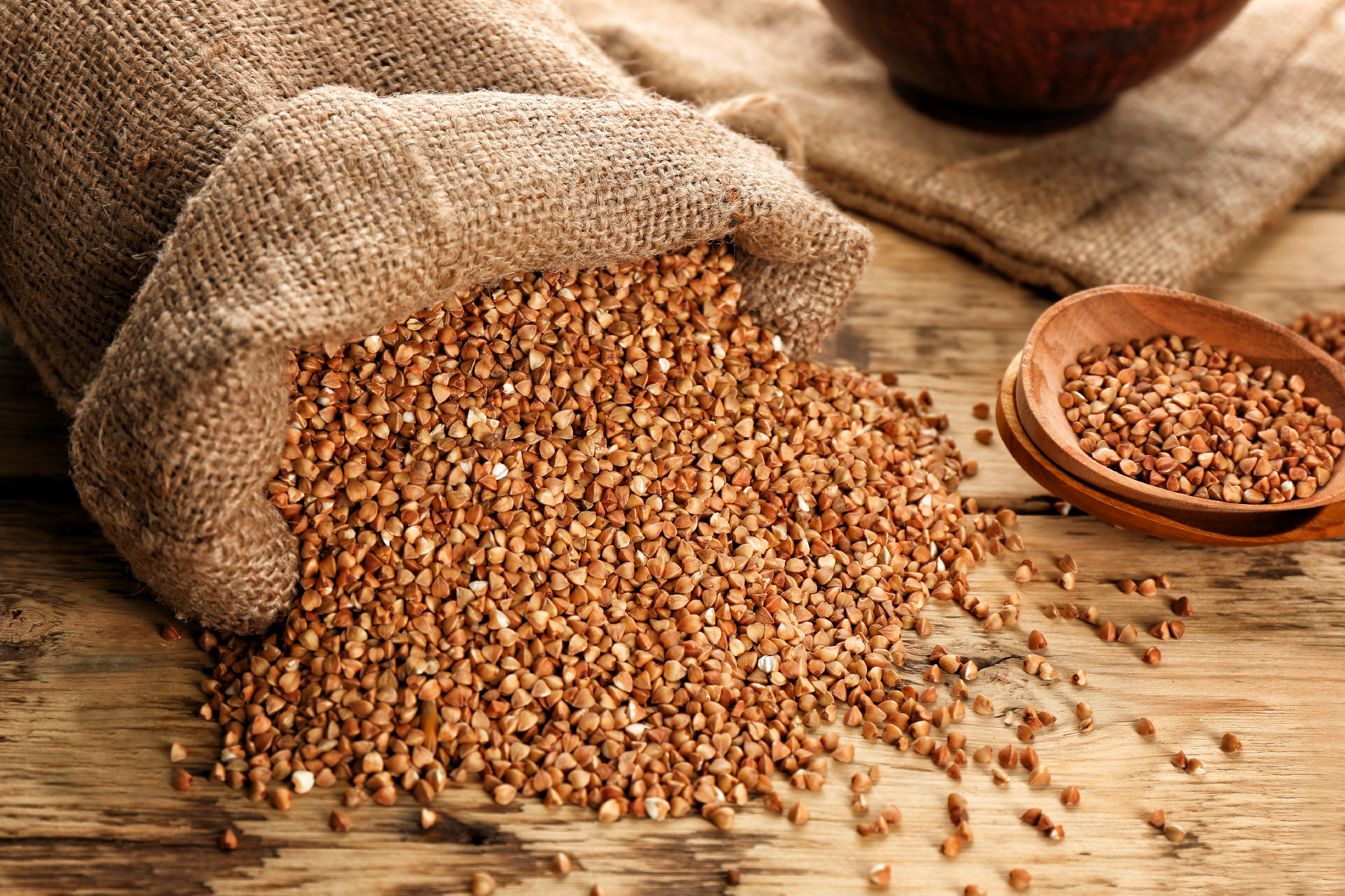 Bag with raw buckwheat on table�