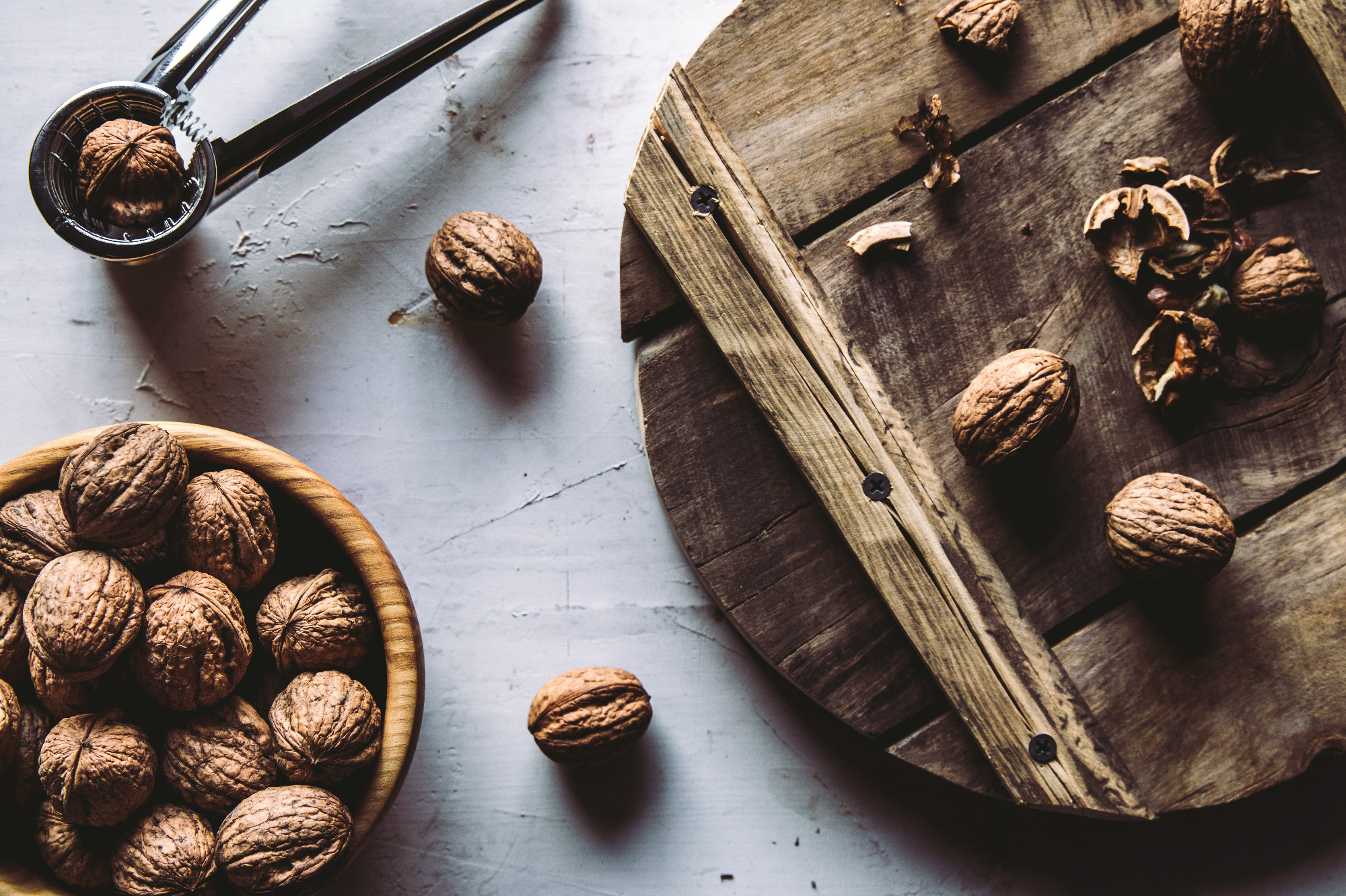Walnuts in wooden bowl on table with Nutcracker.