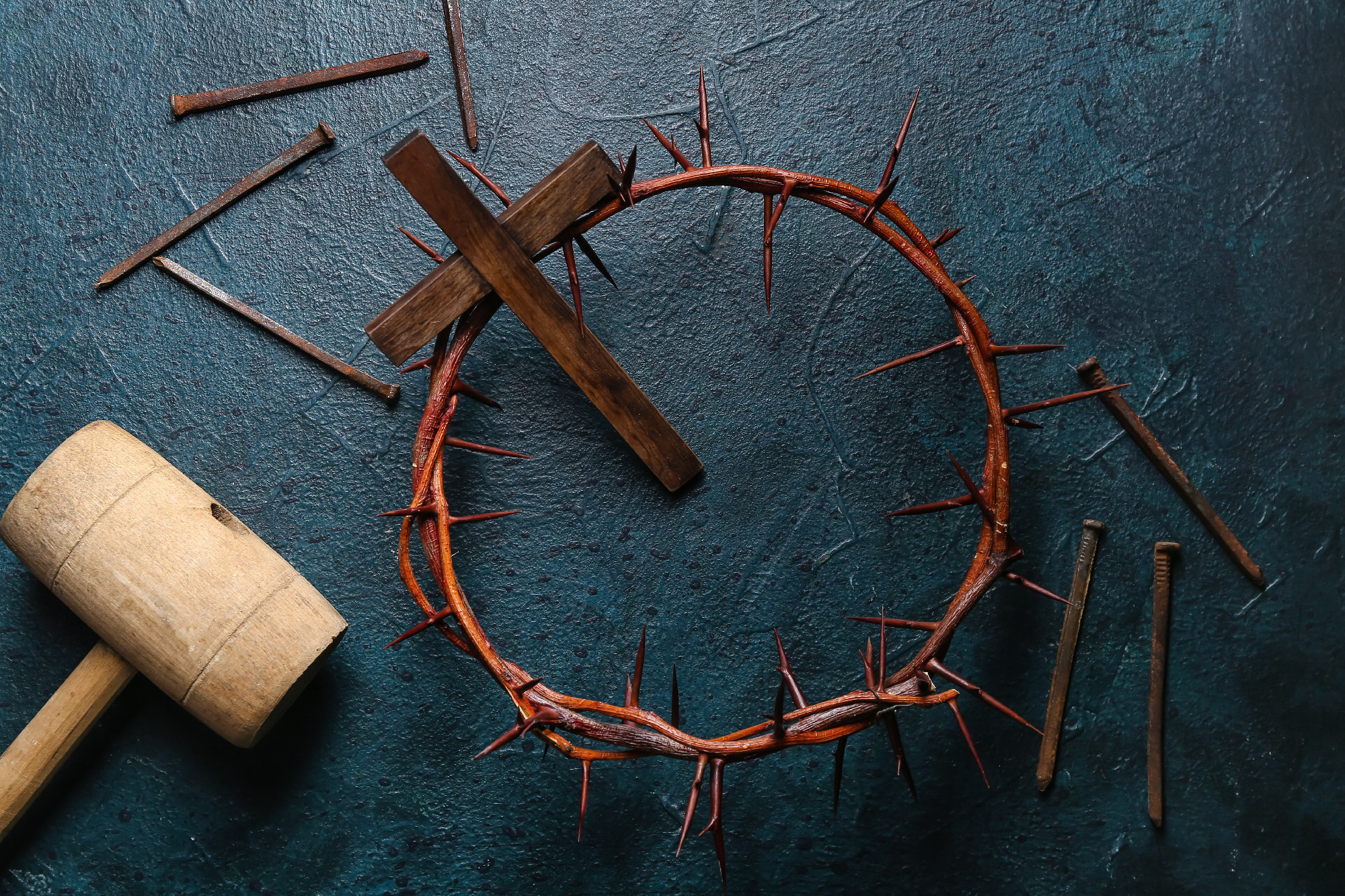 Crown of thorns with wooden cross, mallet and nails on dark background. Good Friday concept�