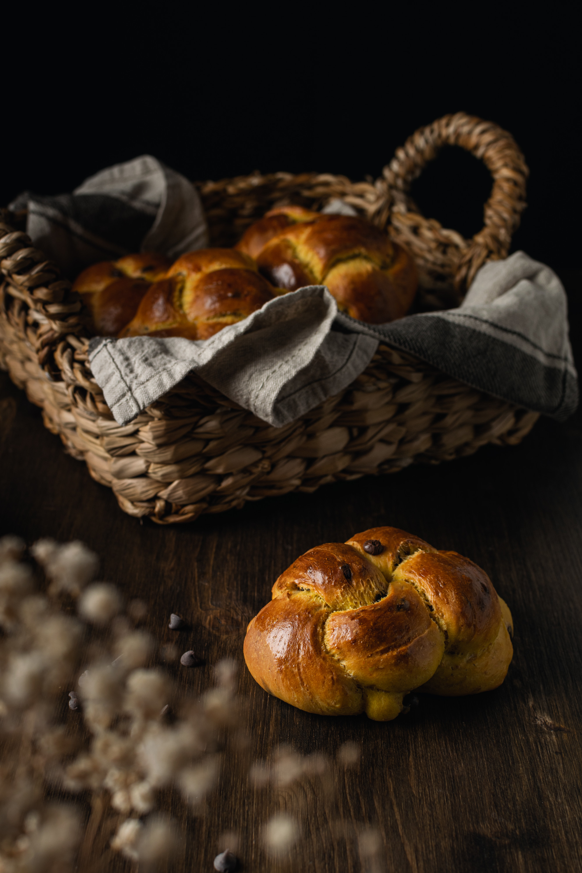 Fresh baked brioche with chocolate chips on dark wooden background