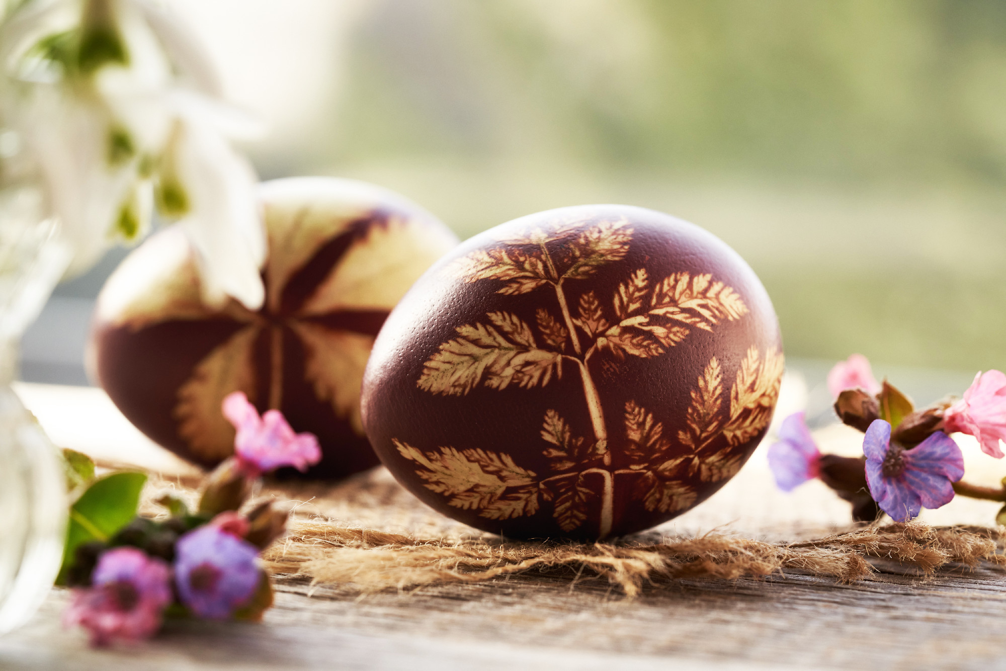 Brown Easter egg dyed with onion skins with a pattern of fresh l