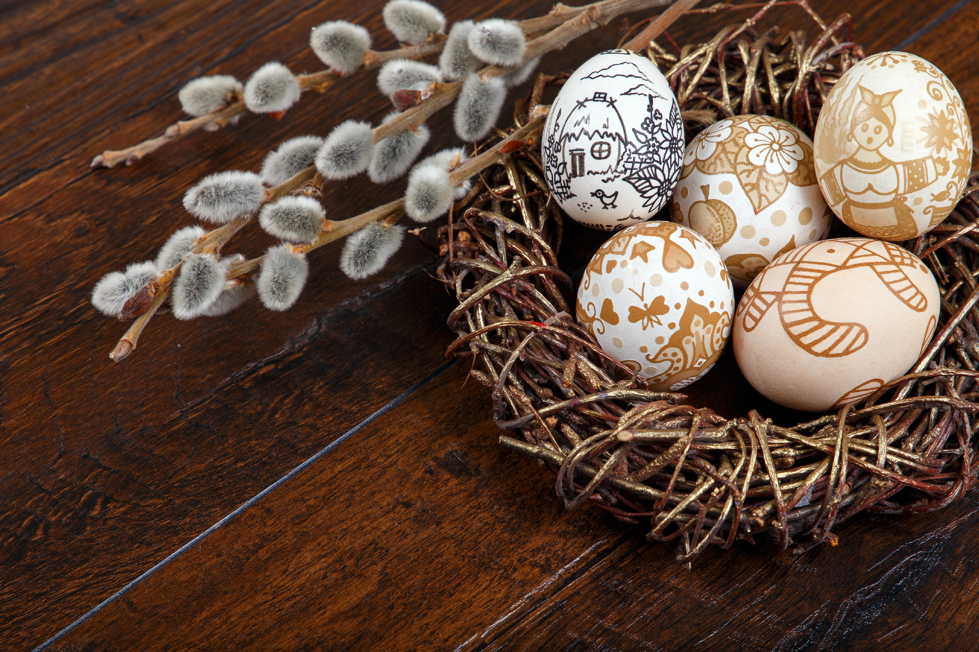 Decorative Easter eggs in a nest on a wooden table