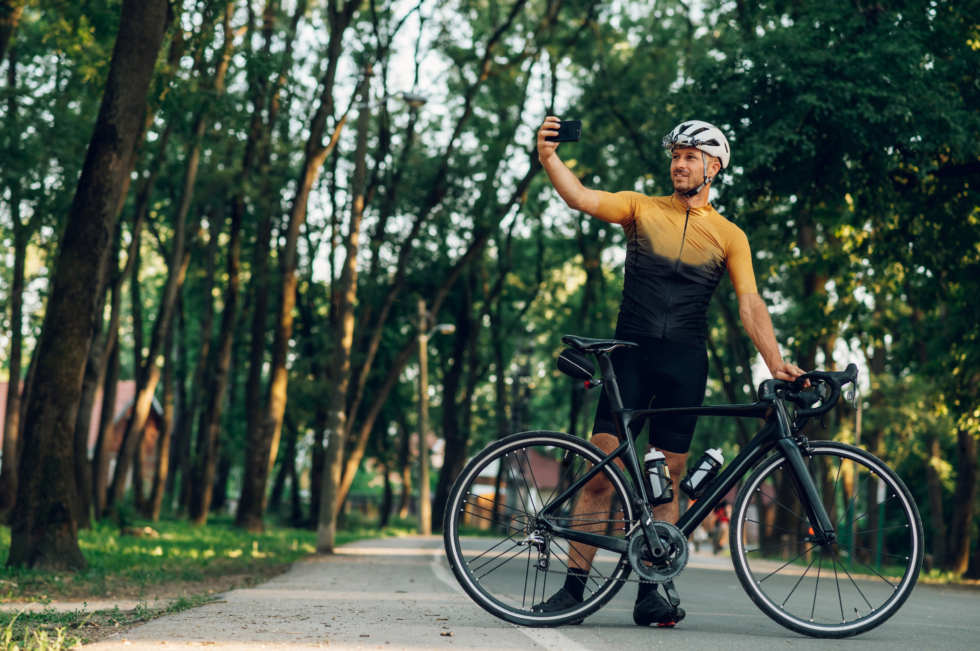 Athletic cyclist in sport taking selfie with a smartphone outdoo