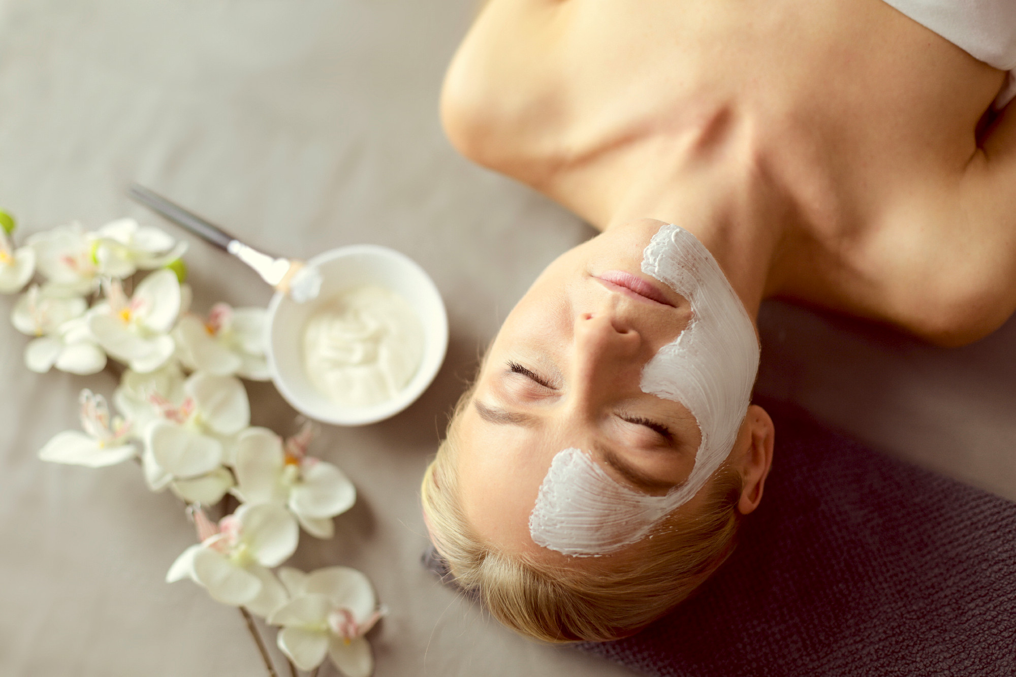 Face mask.Beautiful young girl at spa ,cosmetician woman applyin