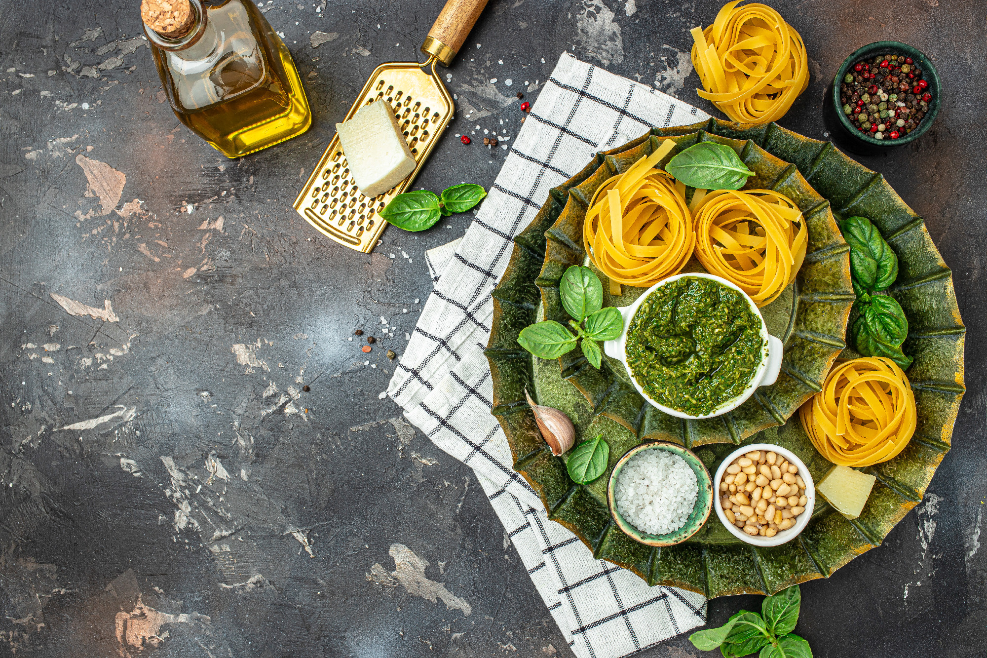 Pasta tagliatelle with pesto sauce on a dark background. Pasta ingredients. banner, menu, recipe place for text, top view