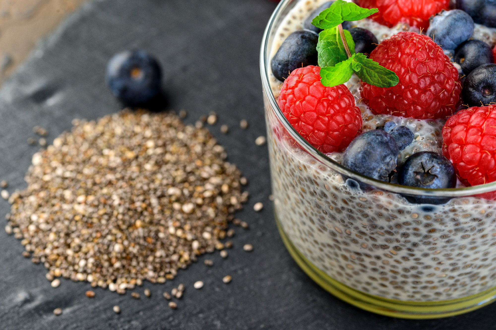 Healthy chia pudding with coconut milk and fresh berry in a glass.