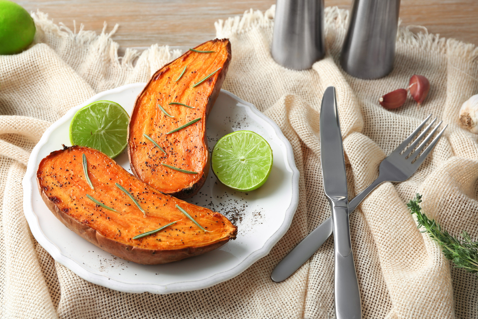 Plate with cooked sweet potato on table�