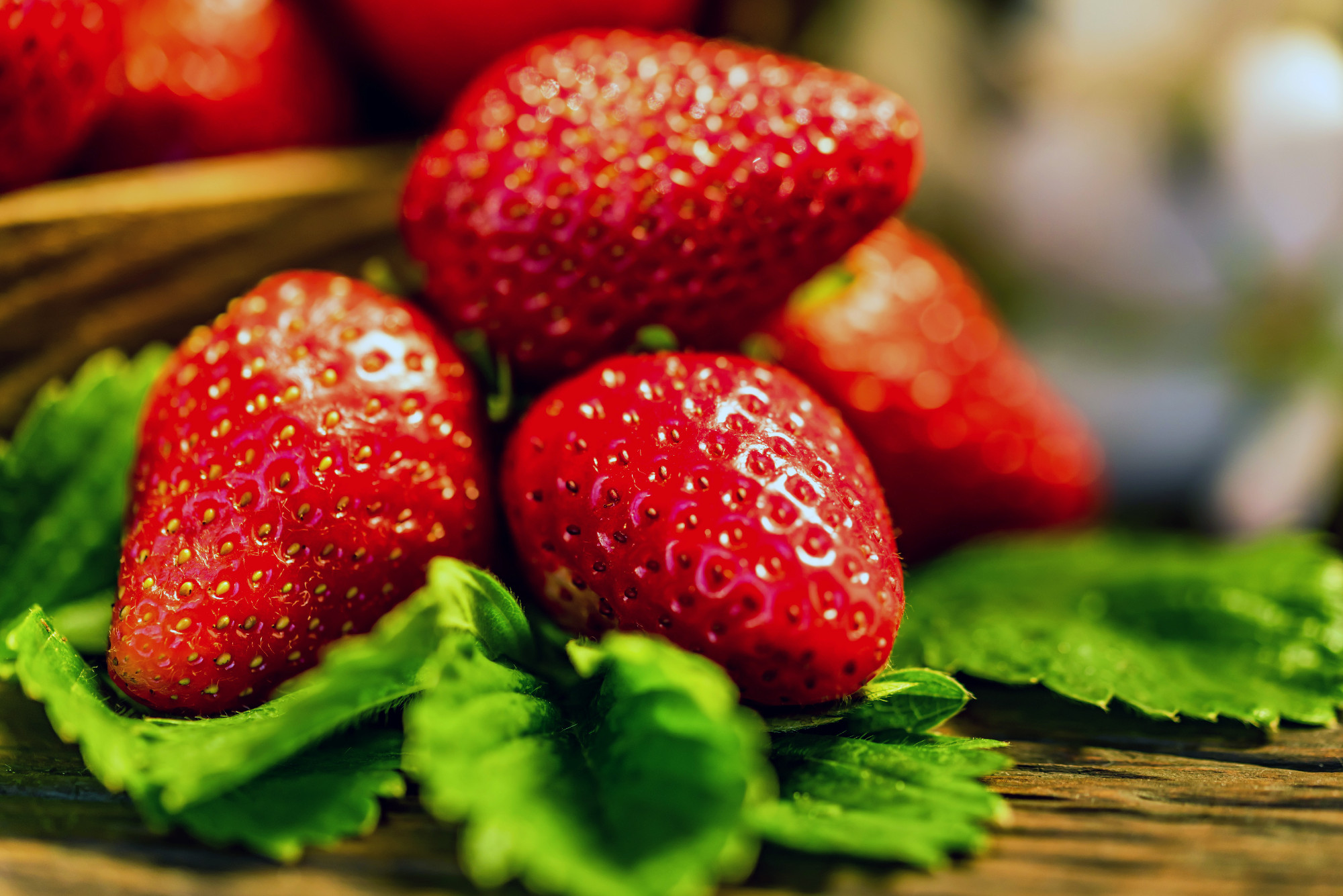Fresh strawberries with leaves in wooden box close