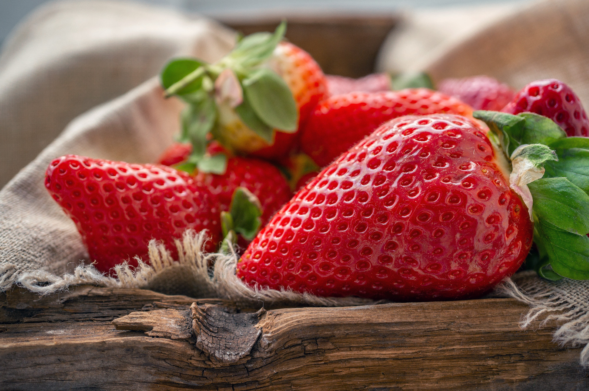 Beautiful ripe strawberries for sale on a tray in wooden containers. without plastic