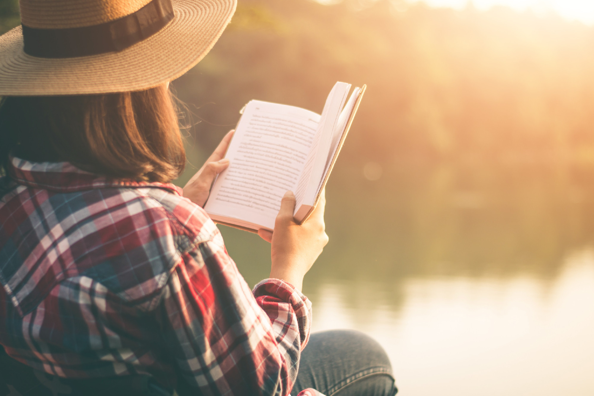 Women tourists read book in quiet nature.