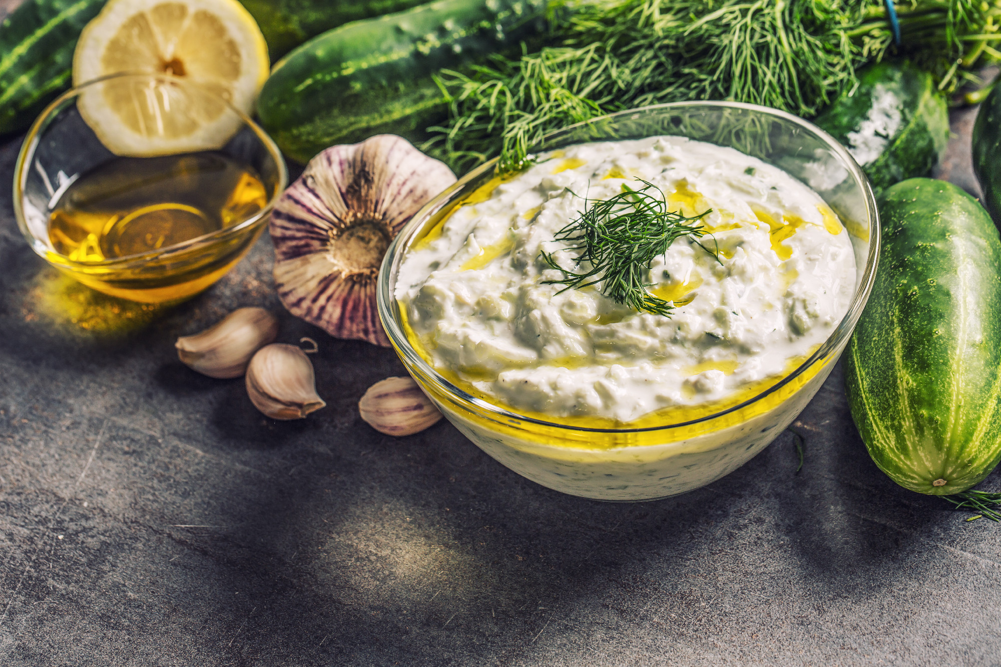 Tzatziki sause in a glass bowl dill cucumber olive oil lemon and garlic