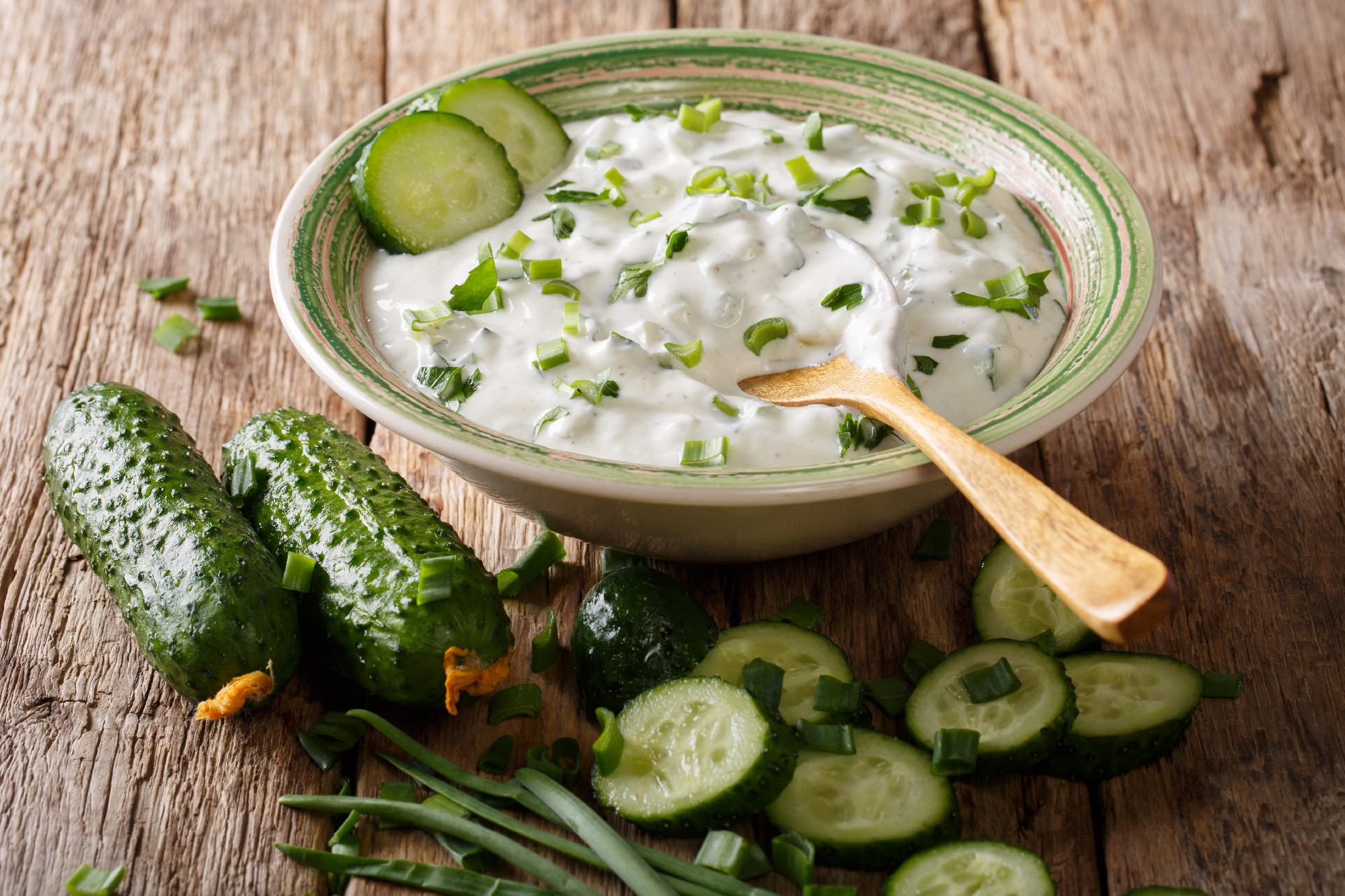 Raita sauce from yogurt with herbs, spices and cucumber close-up