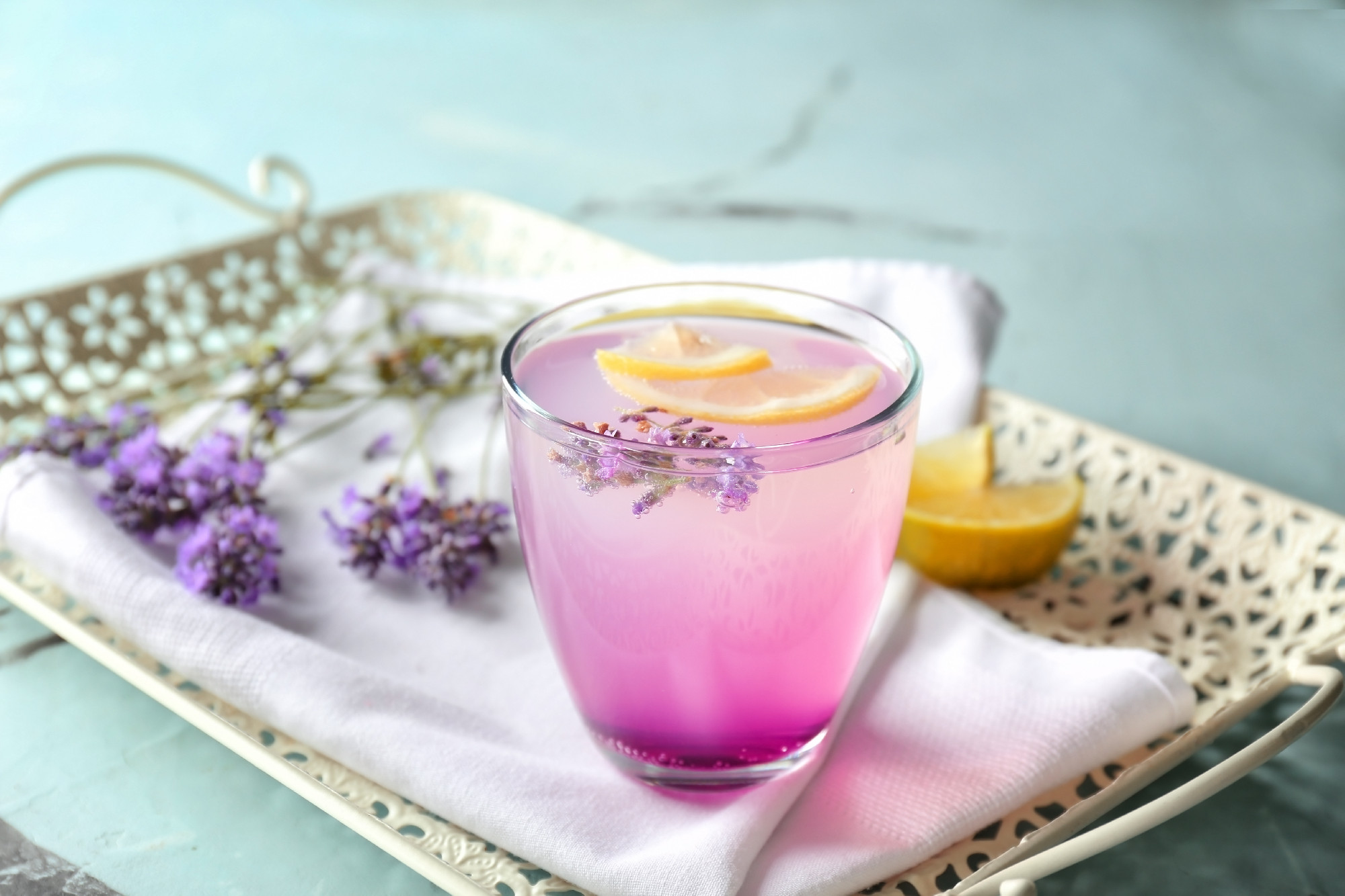 Tray with lavender lemonade in glass on table�