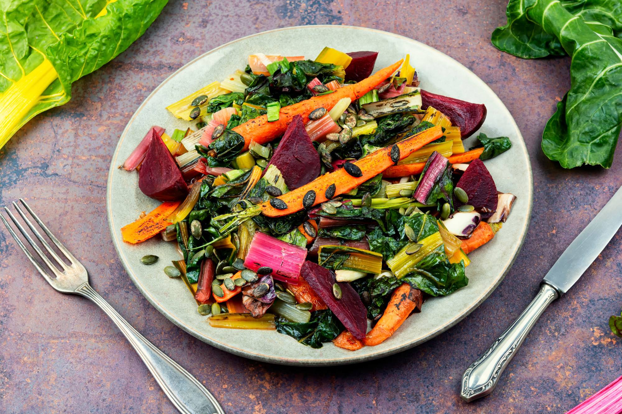 Vegetarian warm salad of stewed vegetables and chard leaves.