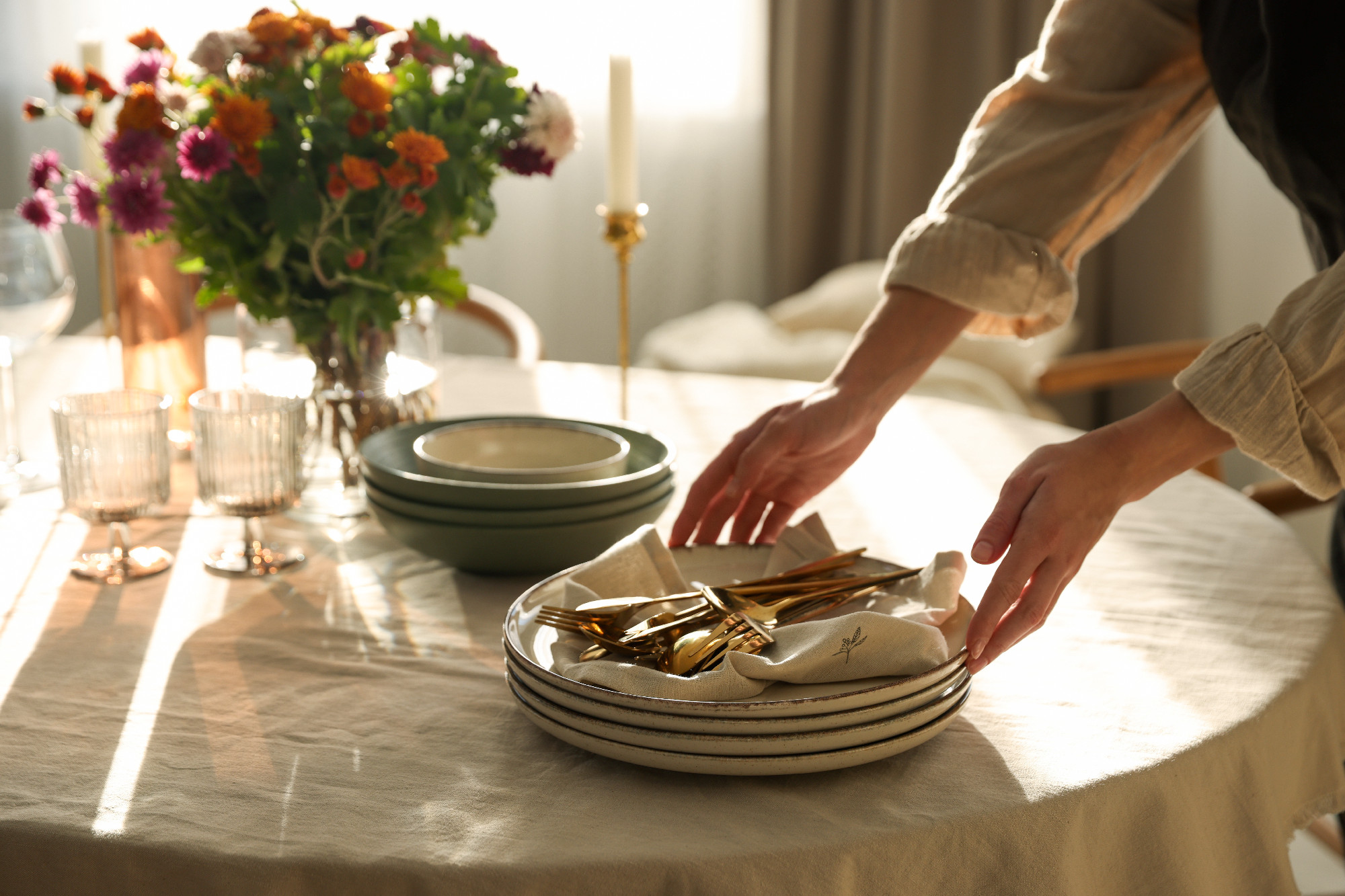 Woman setting table for dinner at home, closeup