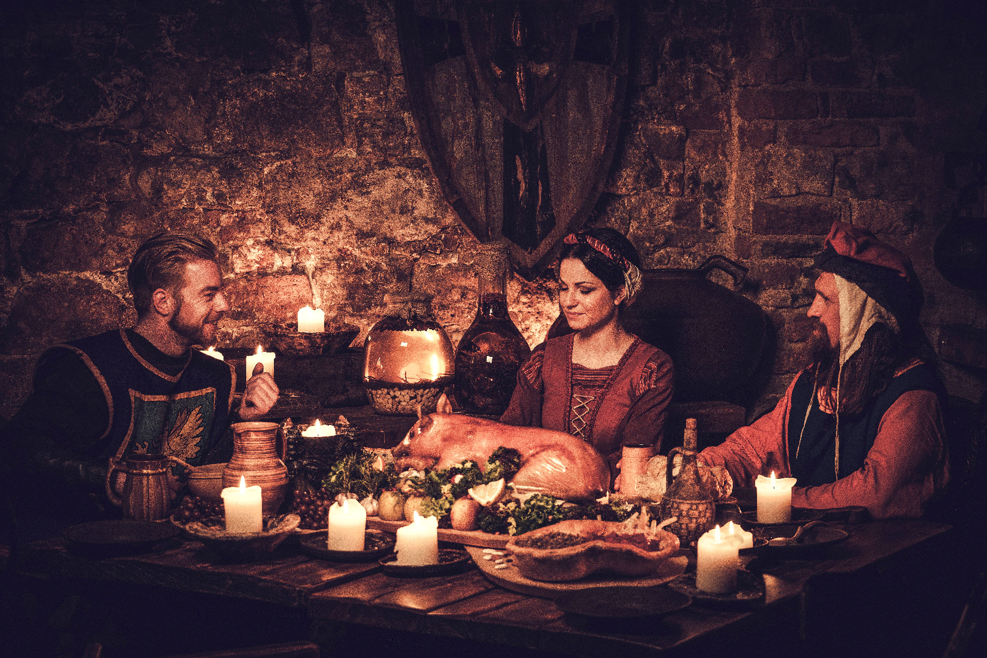 Medieval people eat and drink in ancient castle tavern