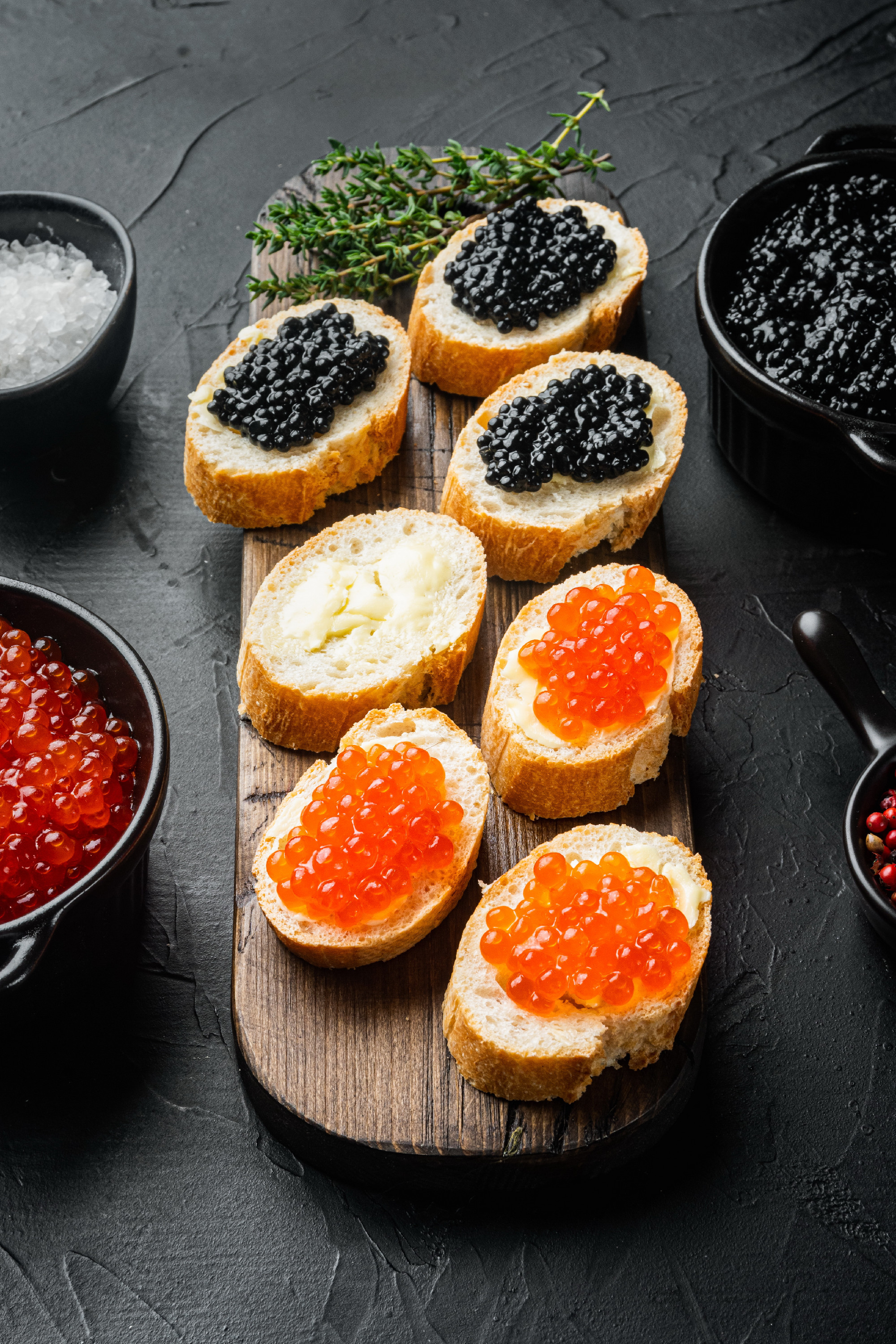 Canapes with black sturgeon and salmon fish caviar, on black bac