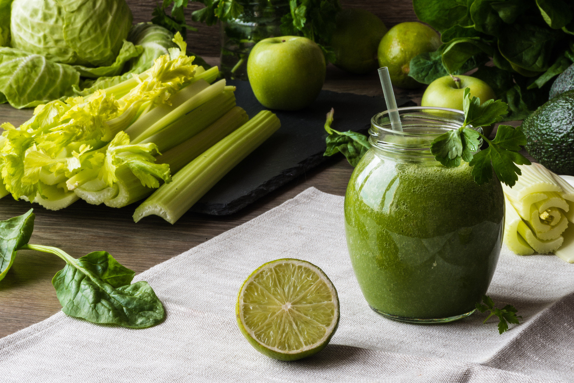 Detox diet. Green smoothie with different vegetables on wooden background